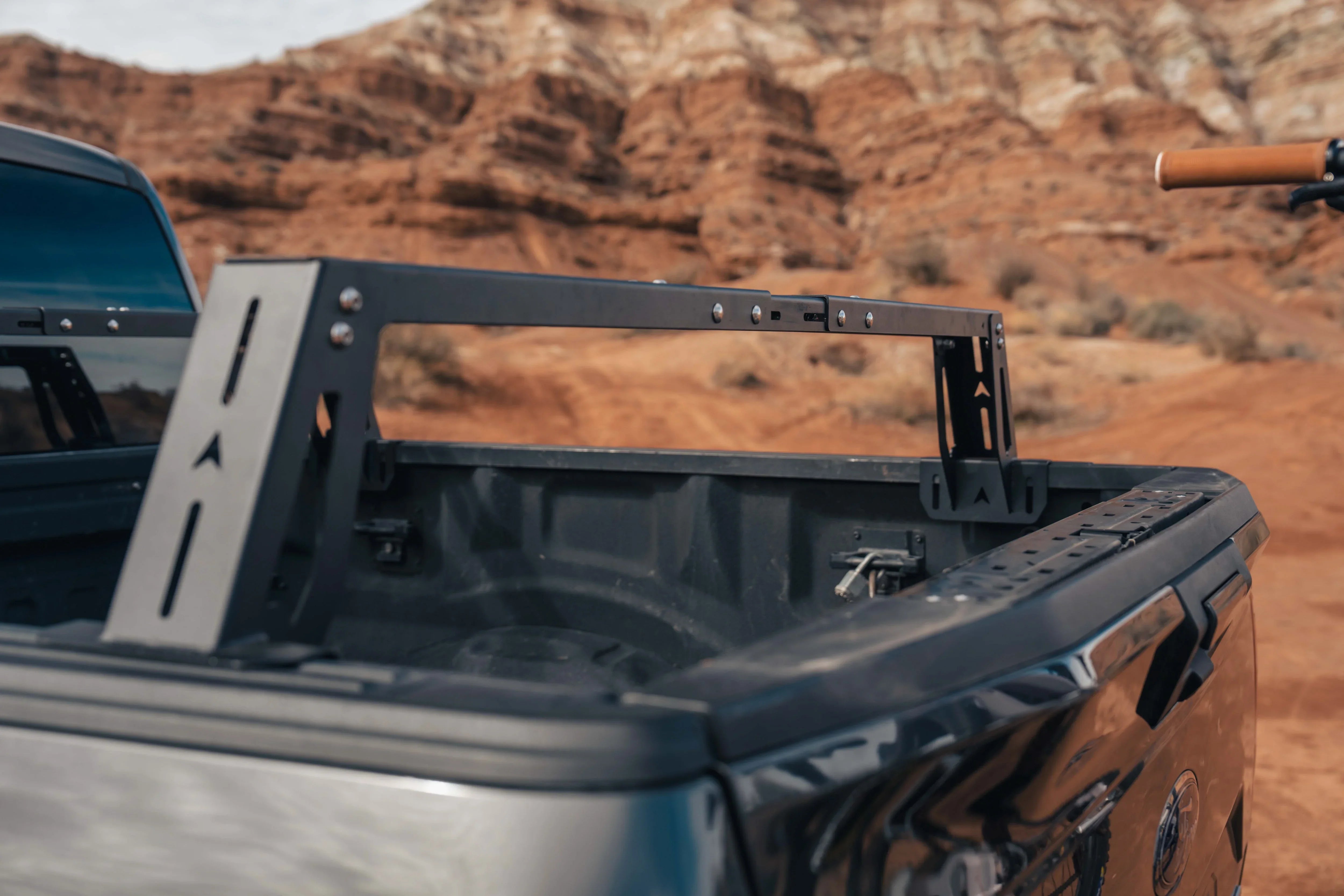 Truck bed rack for overlanding gear installed on pickup, outdoors in a desert landscape