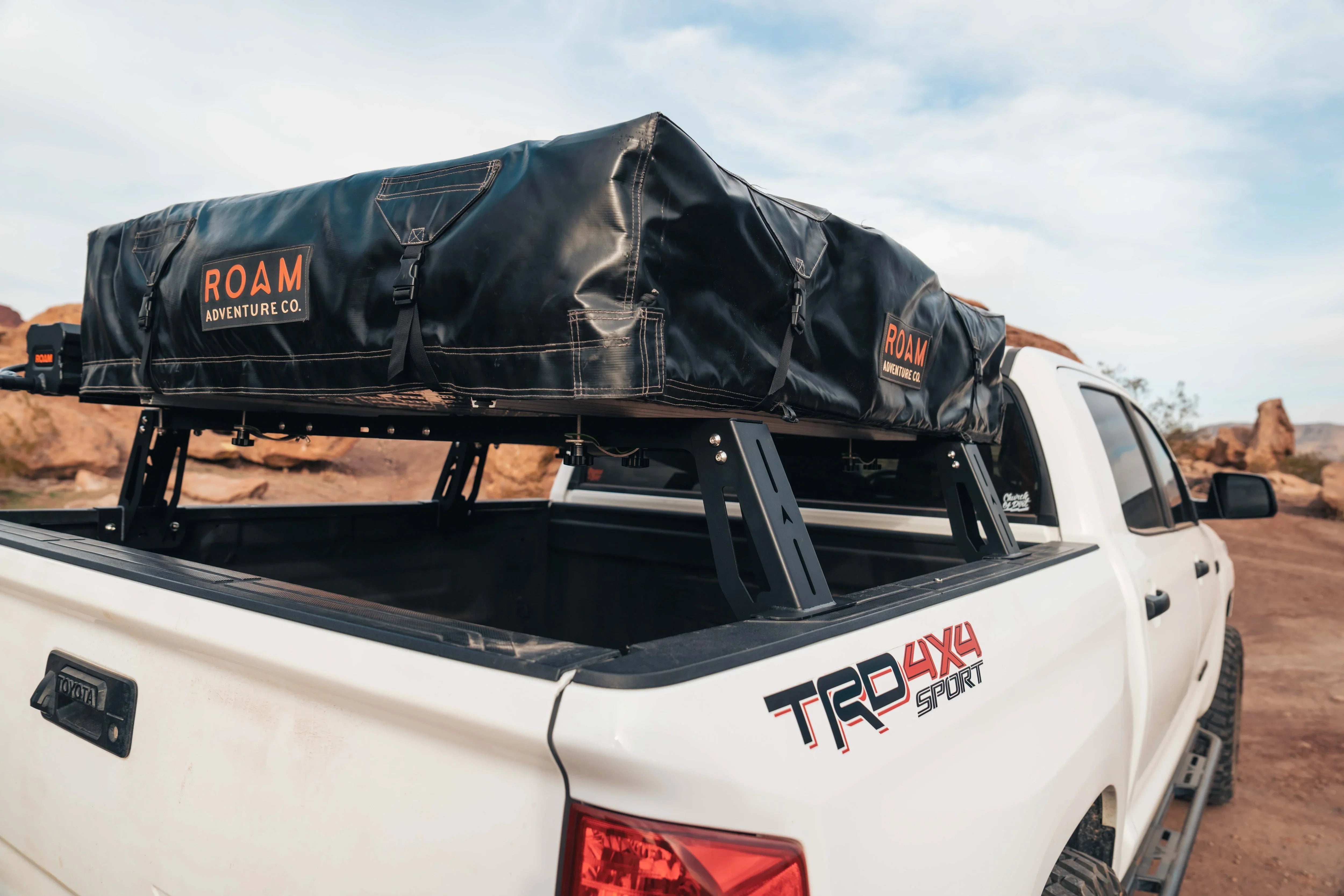 Toyota Tacoma with roof top tent and bed rack, overlanding gear in desert landscape