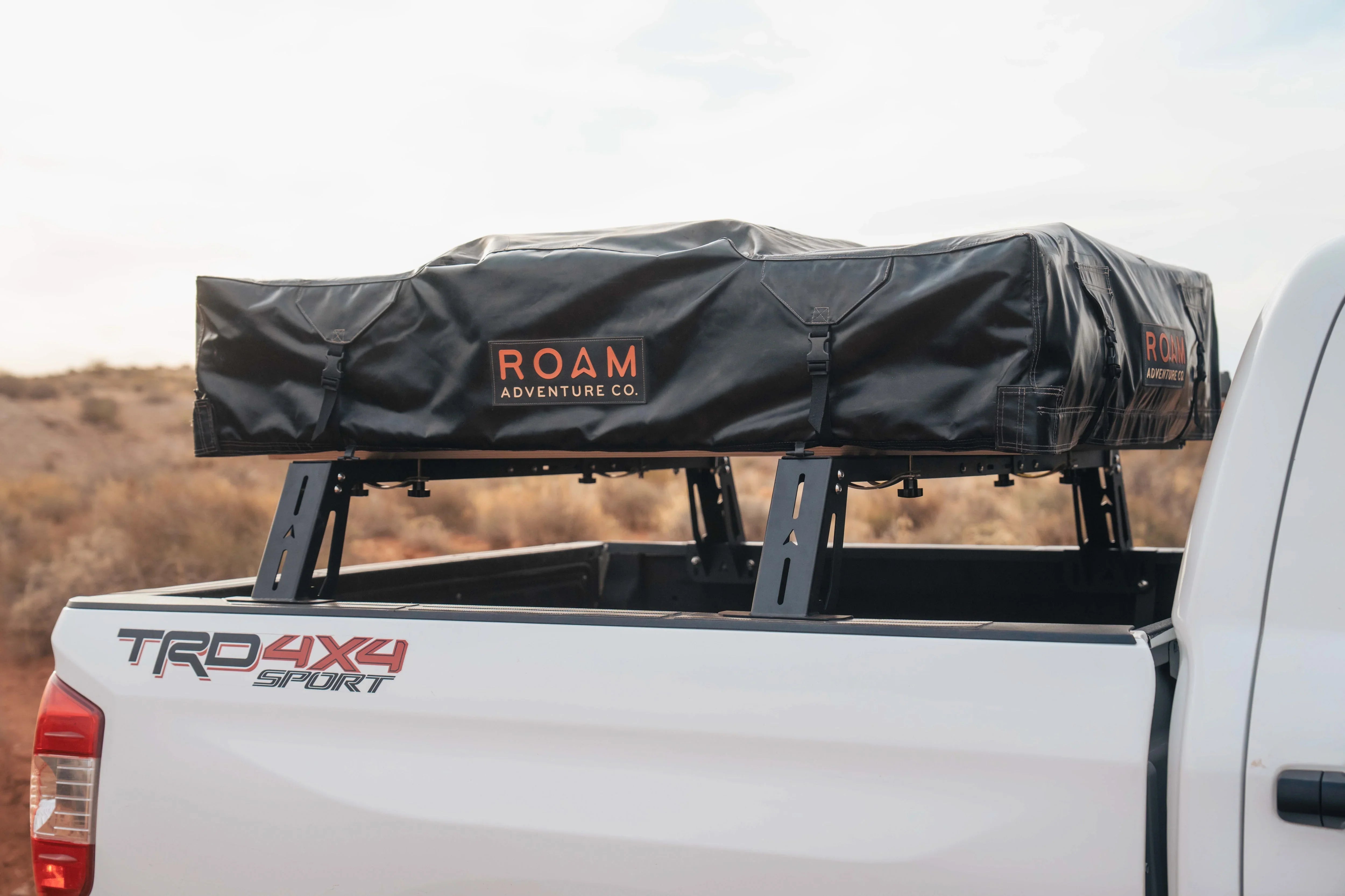 Toyota Tacoma with Roam Adventure Co. rooftop tent mounted on truck bed rack, outdoors