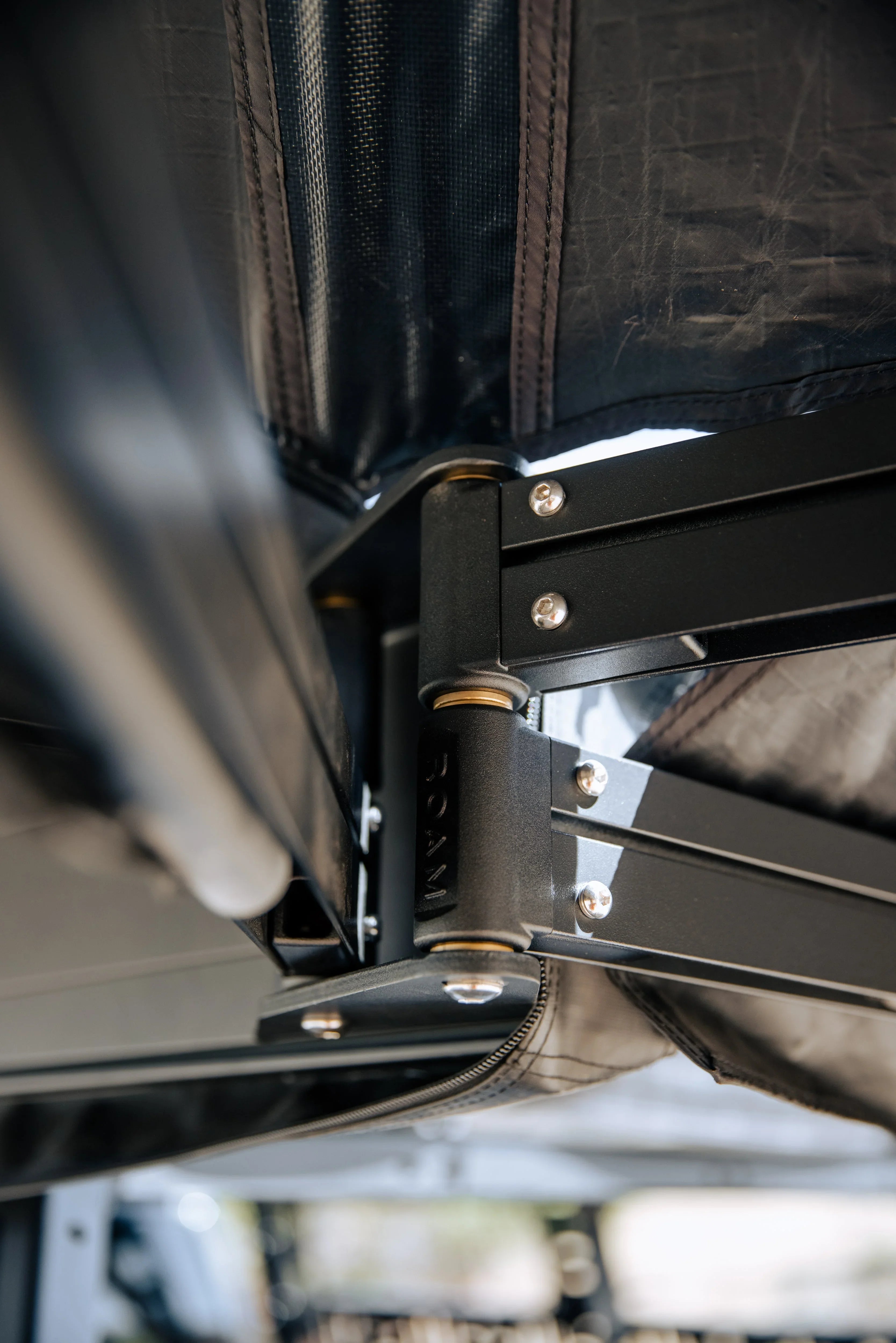 Close-up of heavy-duty rooftop tent hinge and frame for overlanding vehicles