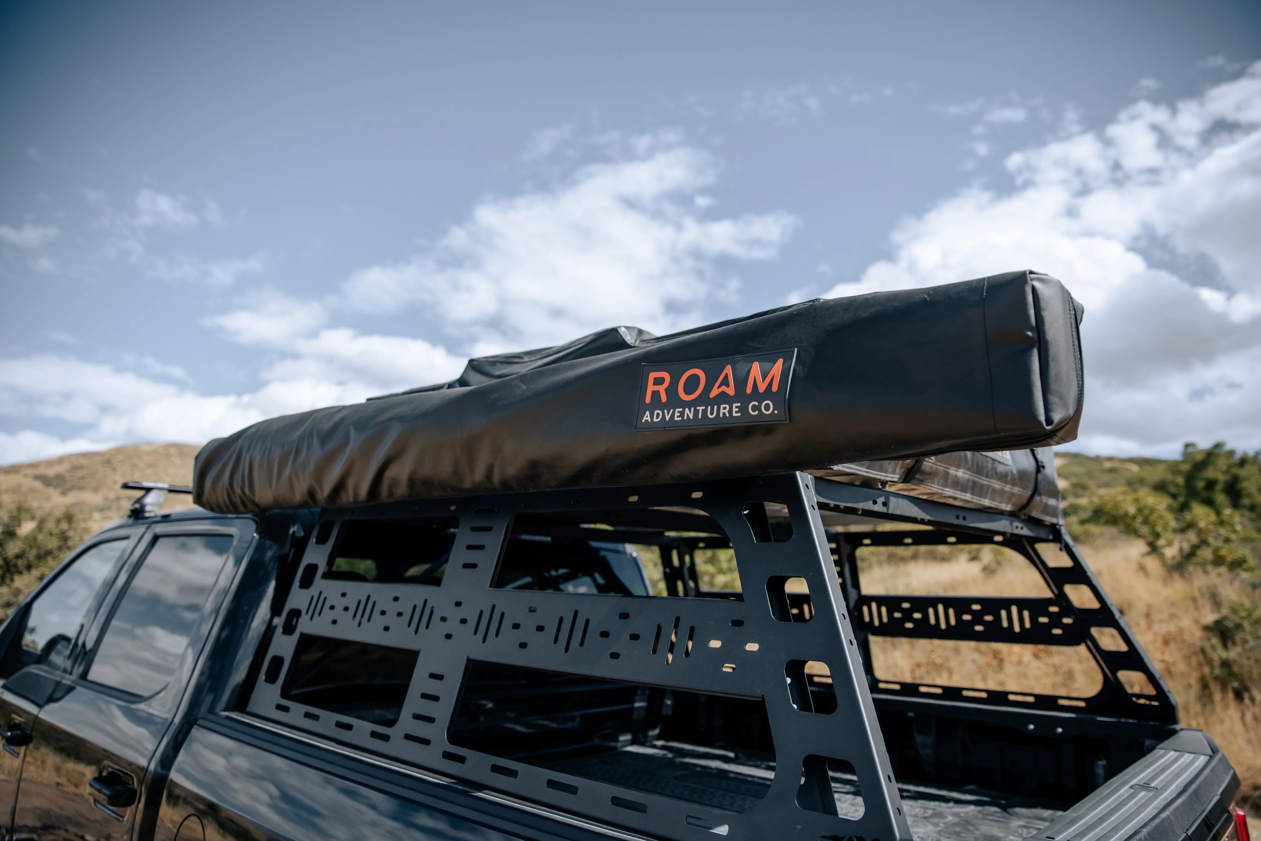 Truck with modular bed rack and ROAM Adventure awning for overlanding and camping