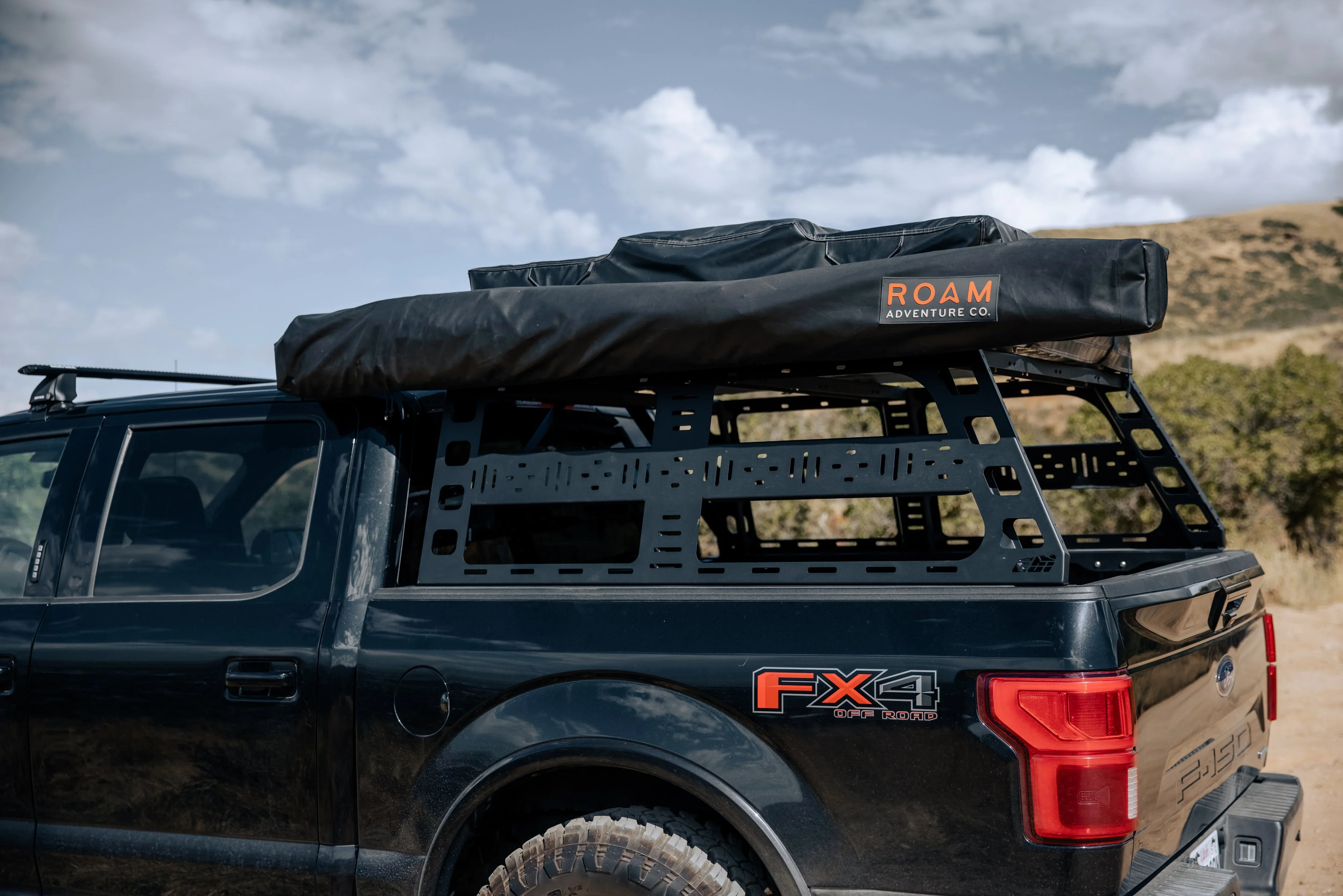 Overland pickup truck with bed rack and rooftop tent for off-road camping adventure