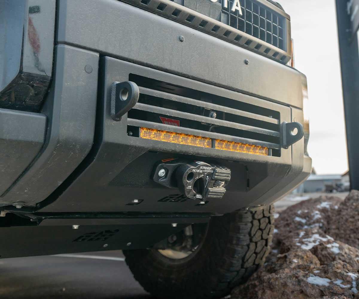 Toyota front bumper with winch, recovery points, and LED light bar for overlanding