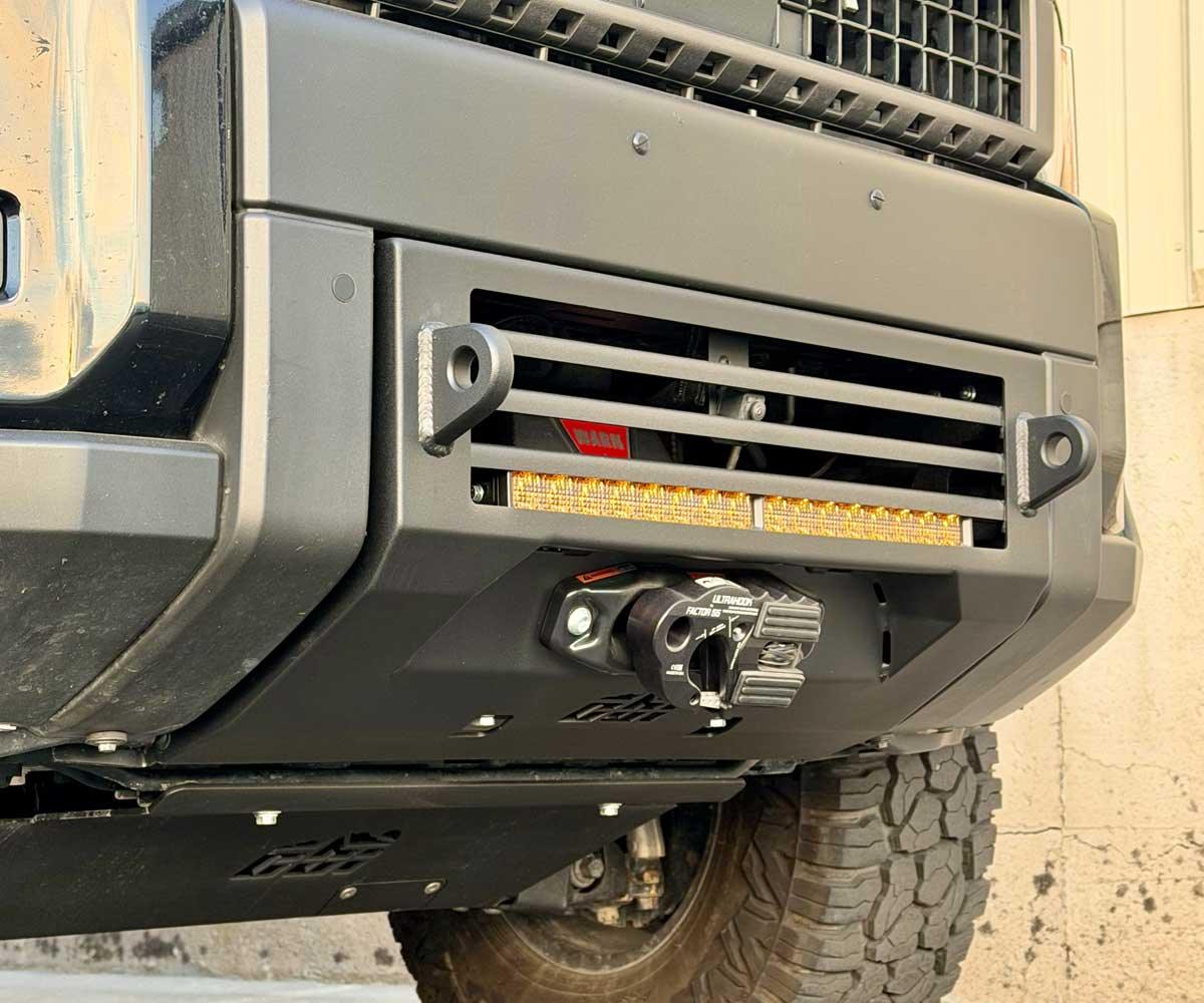 Close-up of off-road vehicle steel front bumper with integrated winch and LED light bar
