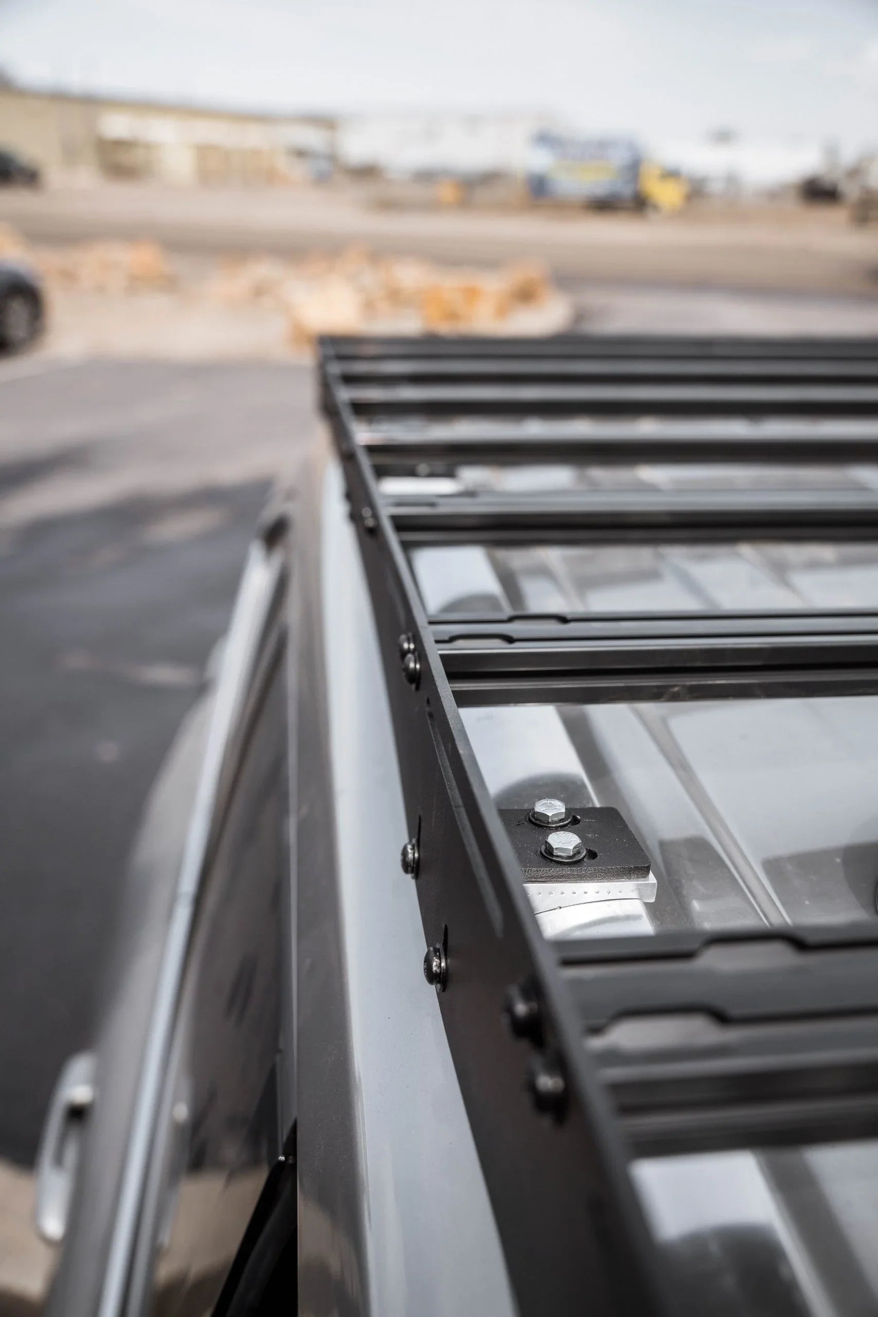 Close-up of a black metal roof rack mounted on a silver overlanding vehicle