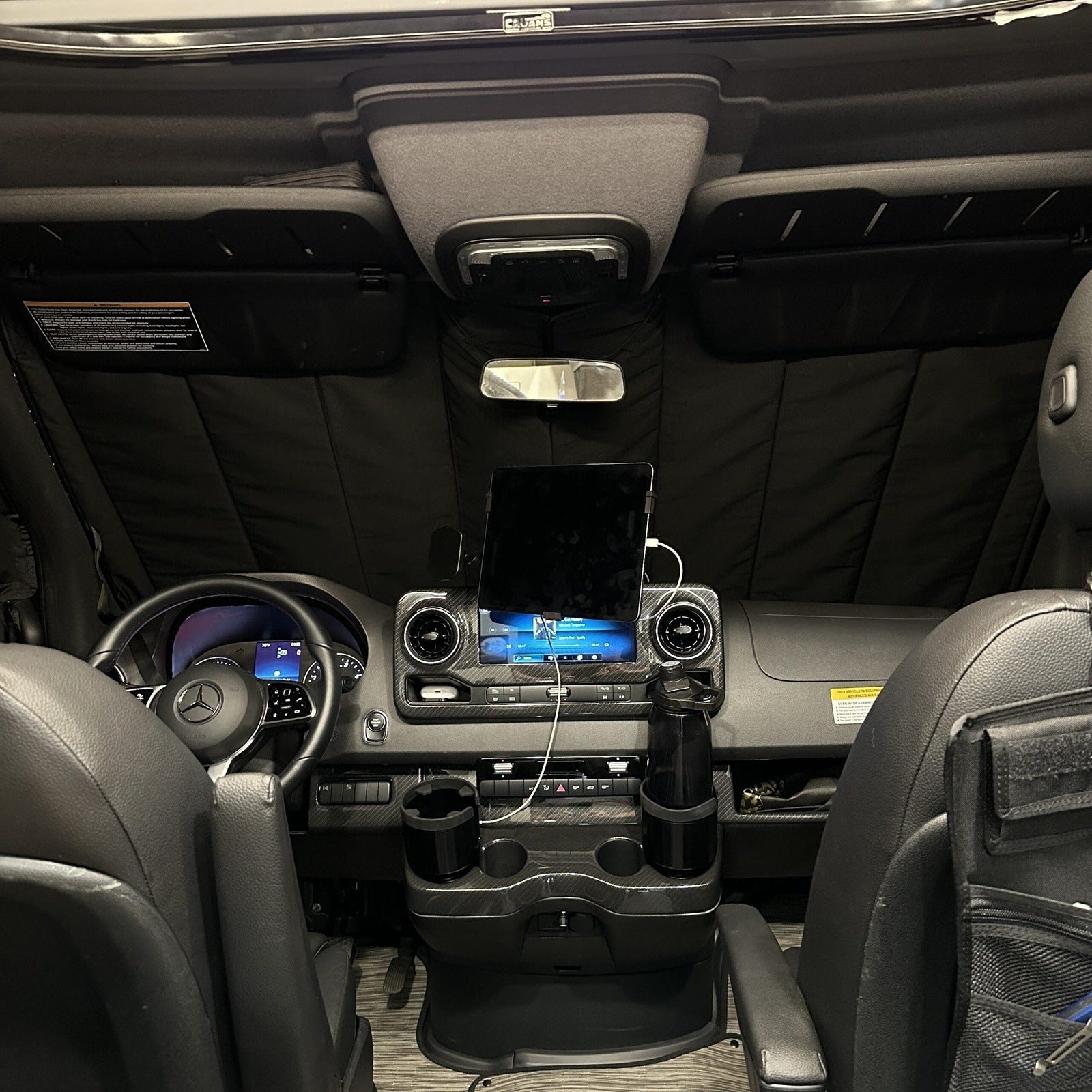 Overlanding vehicle interior with insulated sunshade, dashboard tablet mount, and cup holders