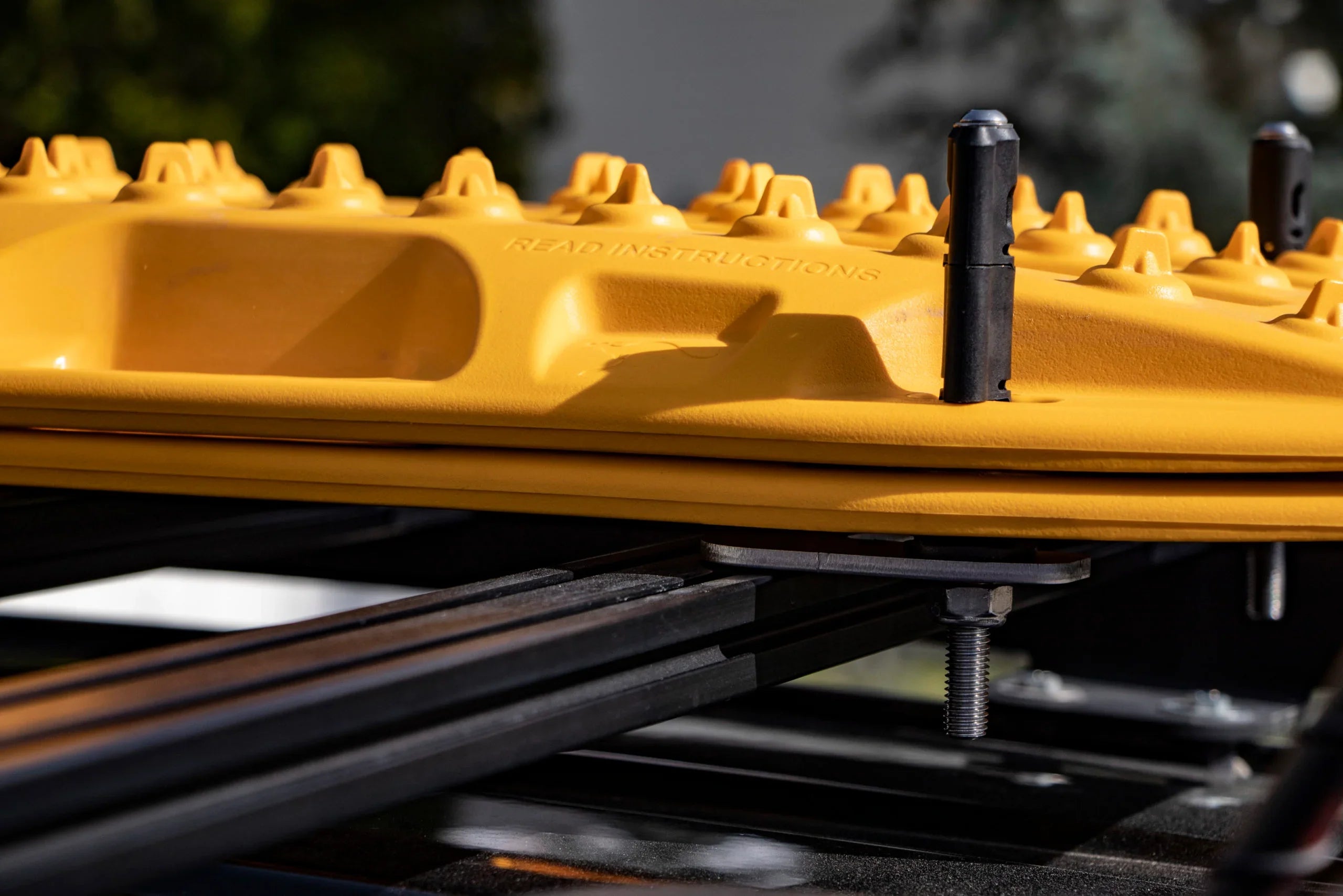 Yellow recovery track mounted on roof rack with mounting hardware for overlanding vehicles