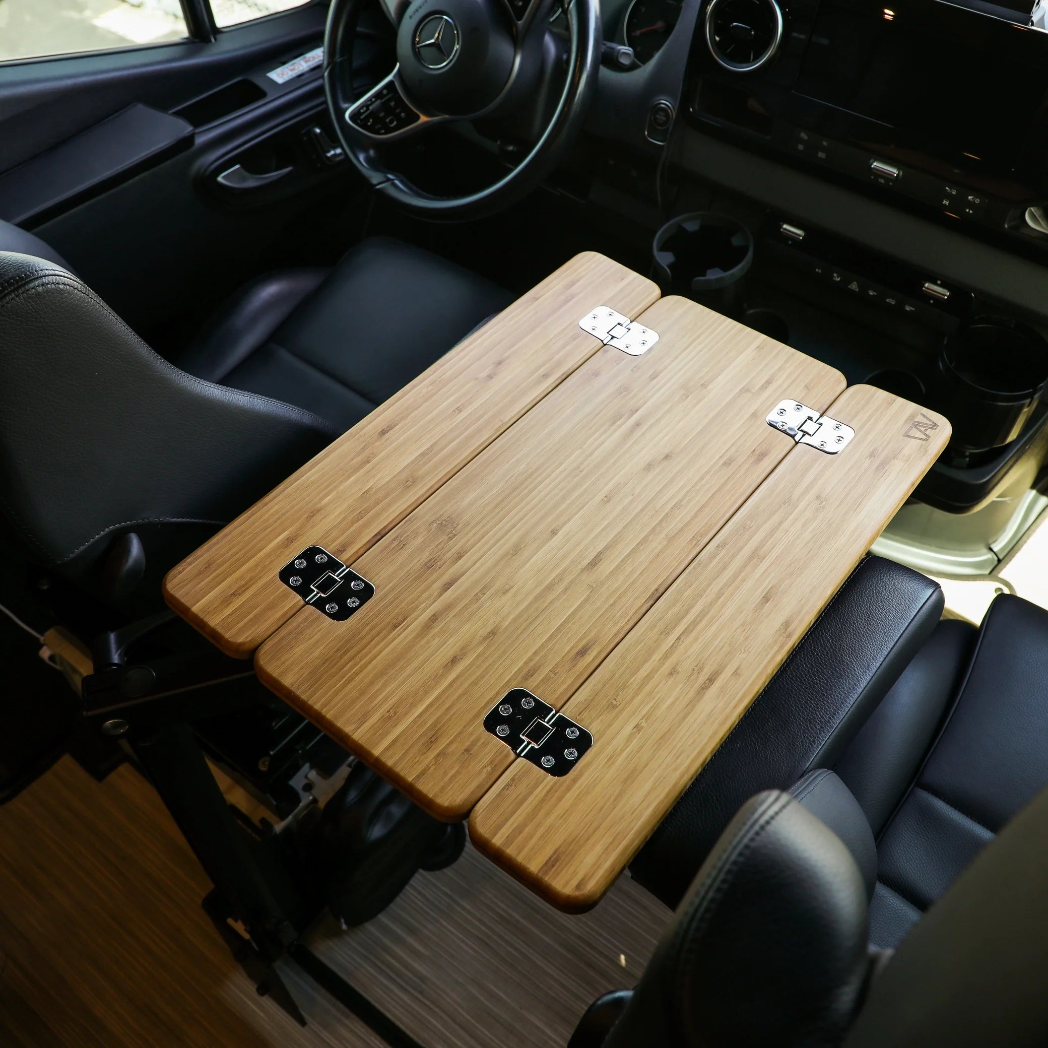 Foldable bamboo campervan table installed in vehicle front seat interior