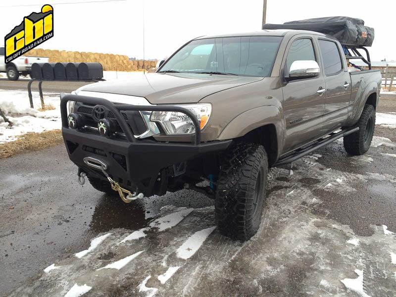 2013 Toyota Tacoma with off-road front bumper, rock sliders, roof rack, and all-terrain tires