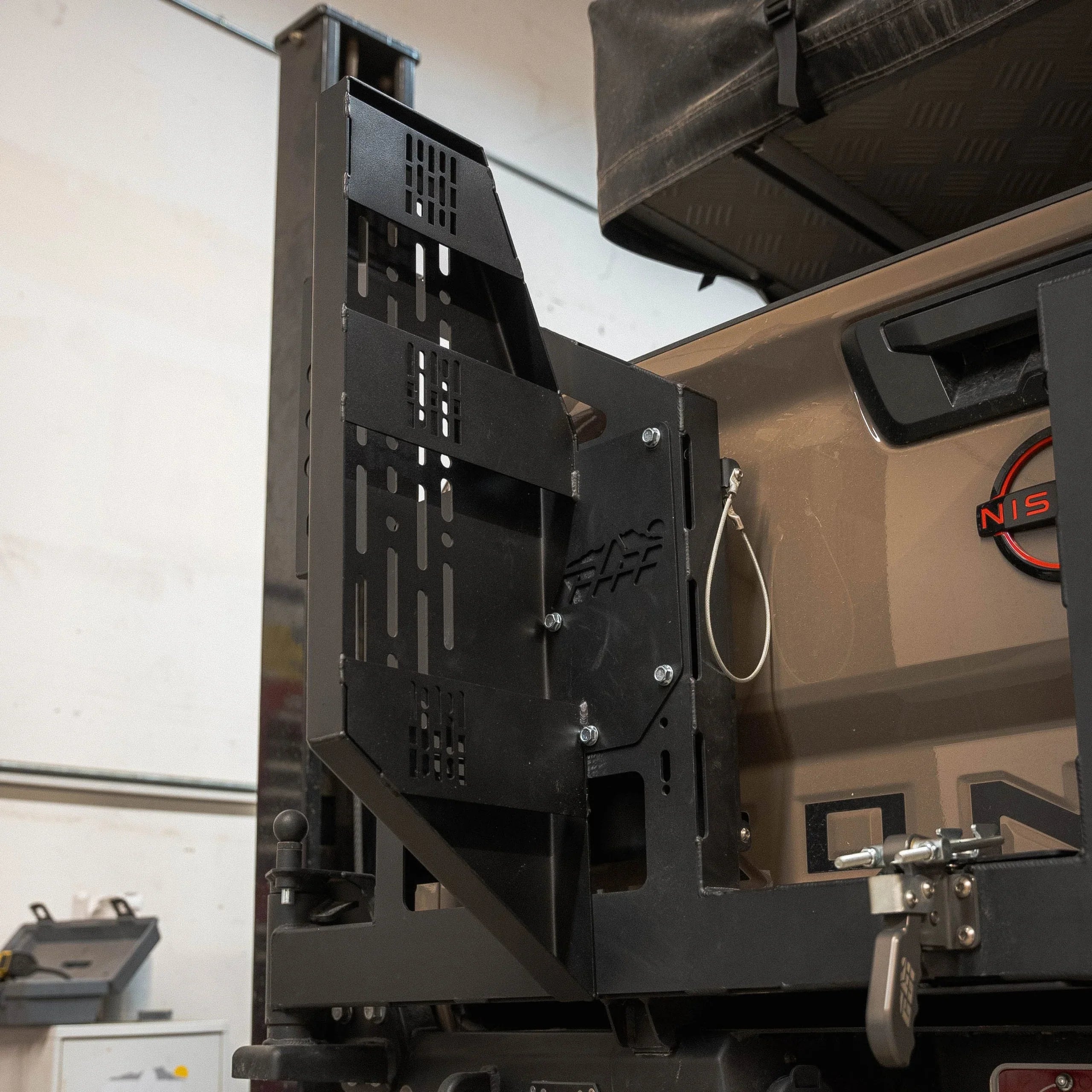 Heavy-duty modular metal mounting bracket attached to off-road vehicle tailgate