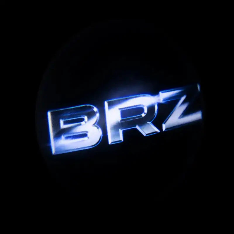 Illuminated BRZ car door projector light logo on dark background