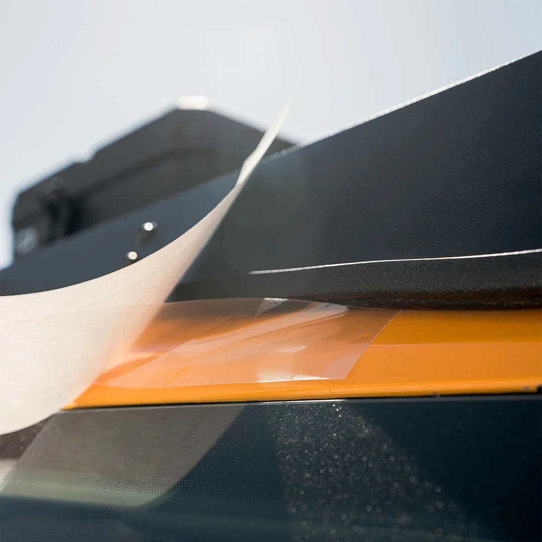 Close-up of clear paint protection film being applied to a vehicle roof rack section