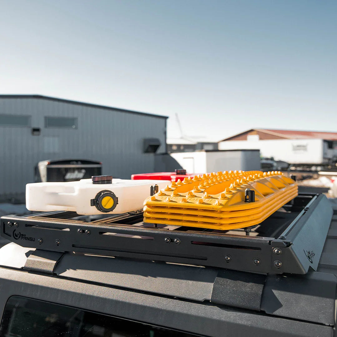 Roof rack with off-road recovery boards and fuel cans mounted on a vehicle