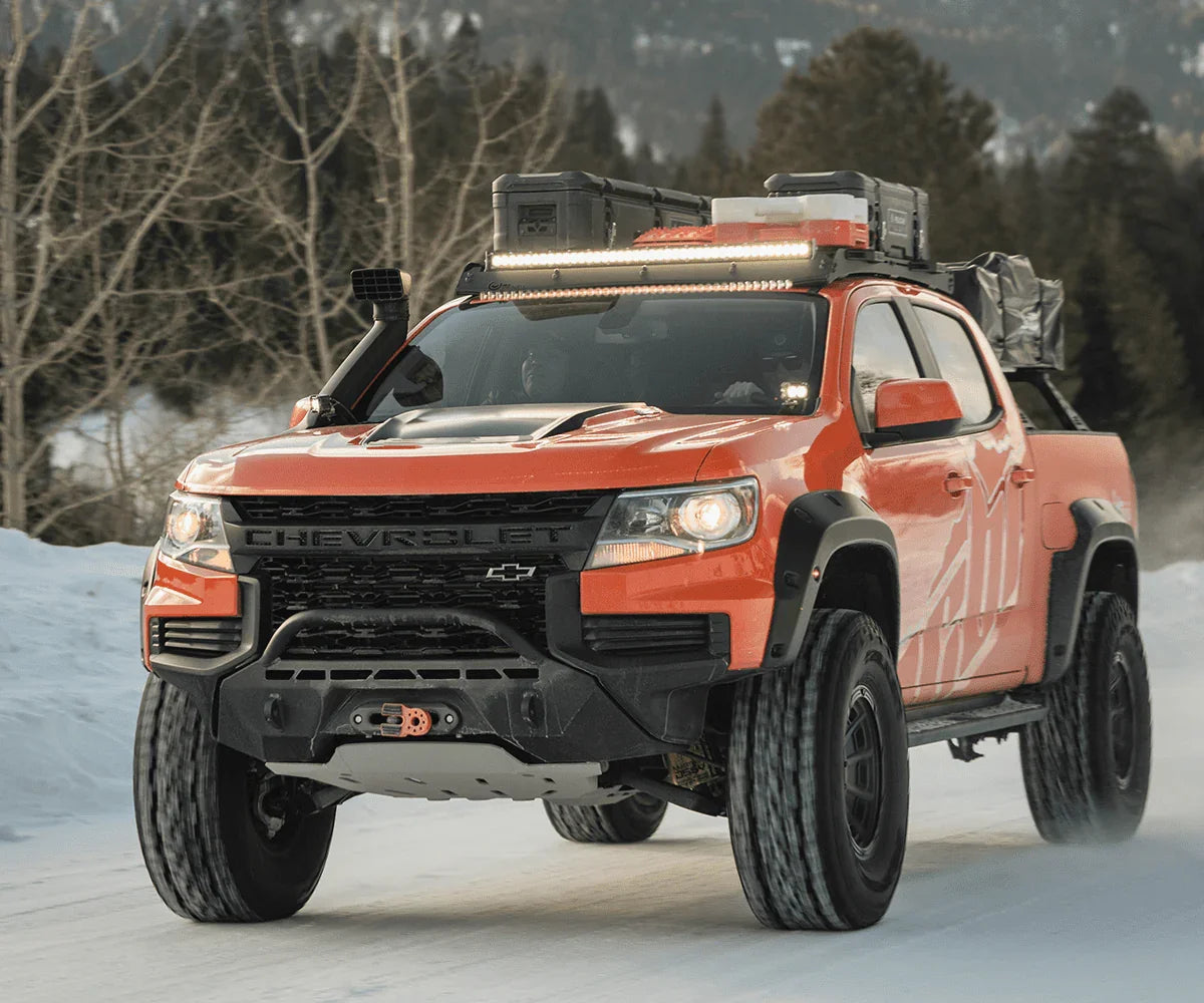 Chevrolet Colorado truck with Prinsu roof rack and gear, off-road in snowy wilderness