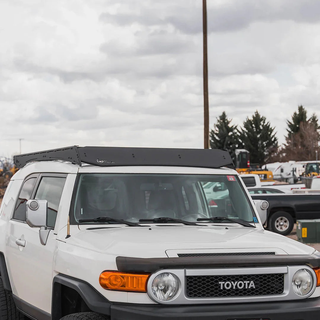 Toyota FJ Cruiser with black roof rack in parking lot, front view
