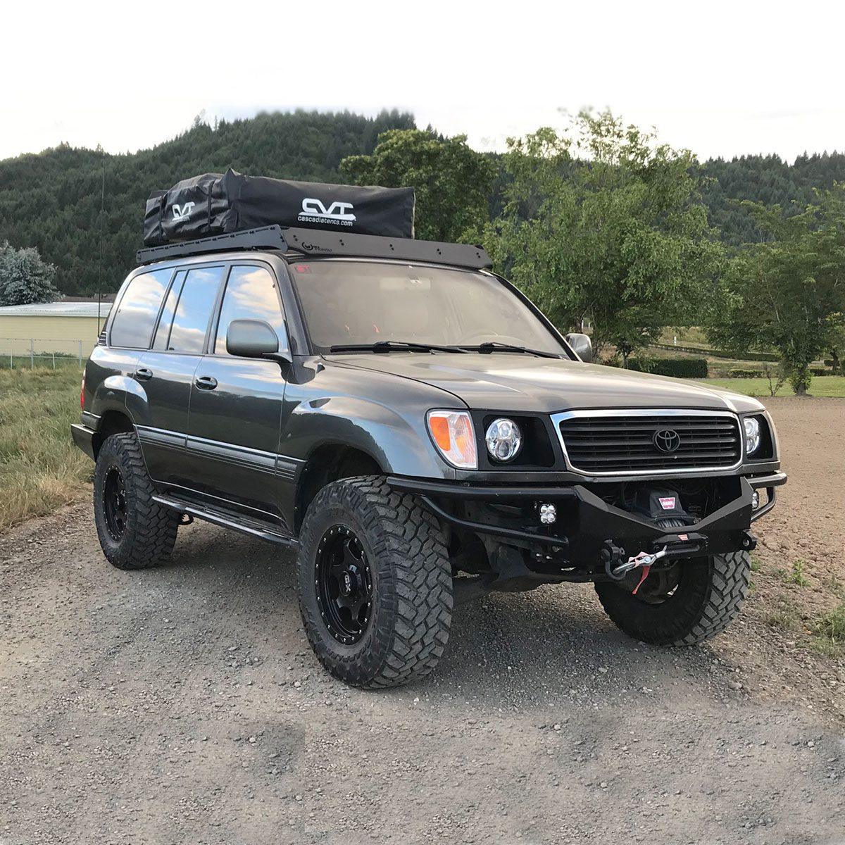 Toyota Land Cruiser 100 Series with roof rack and rooftop tent on dirt road