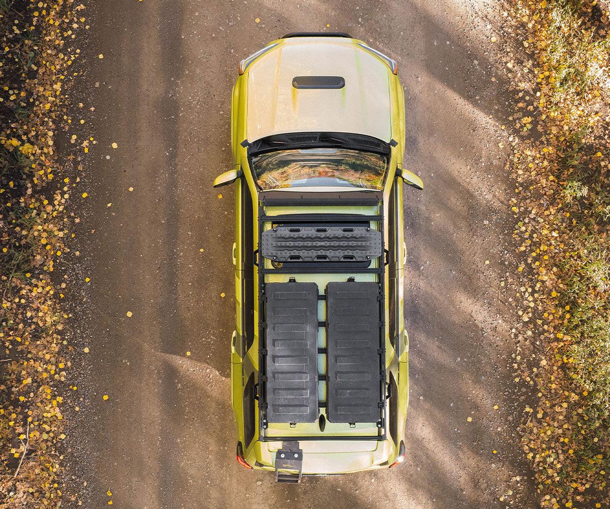 Toyota 4Runner with overland roof rack and gear boxes on a dirt trail, top view