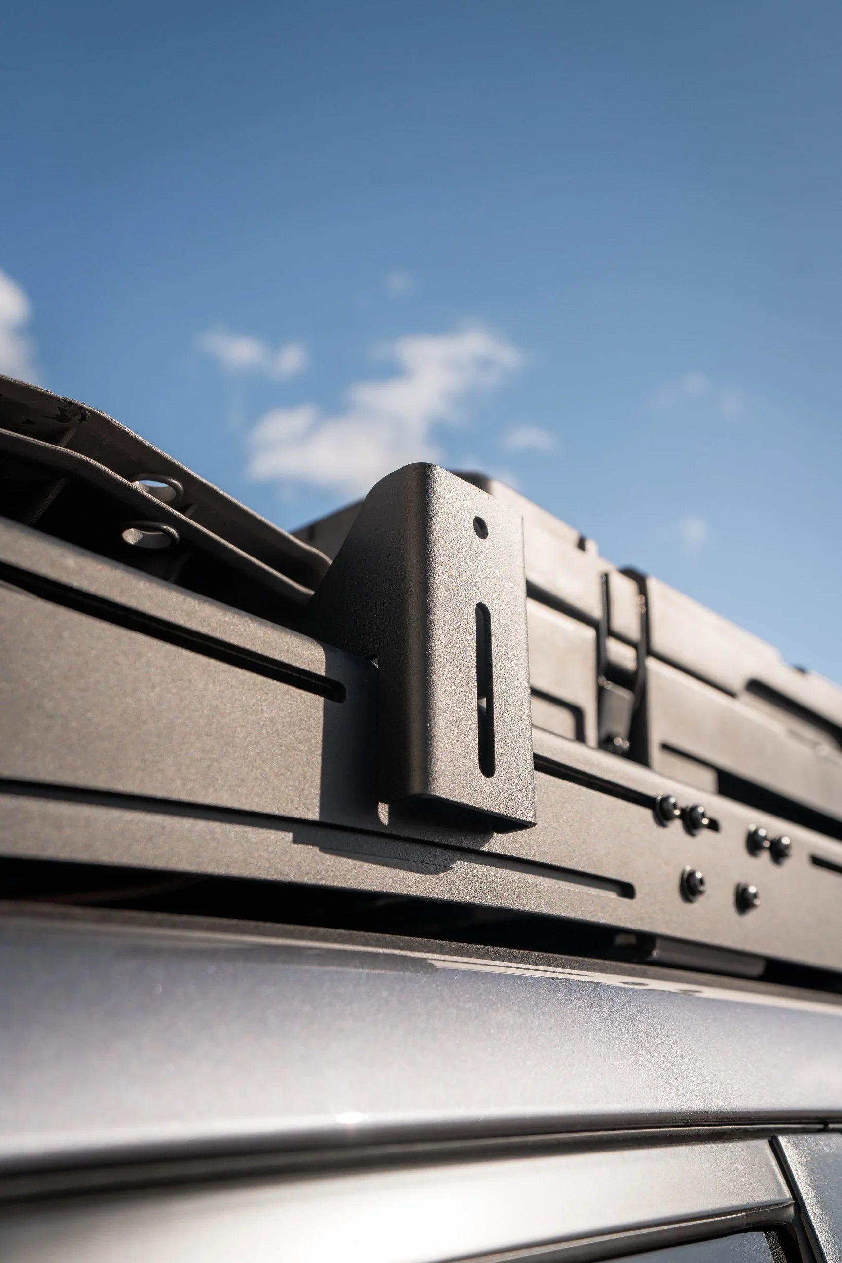Close-up of pro awning mount bracket installed on vehicle roof rack for overlanding gear