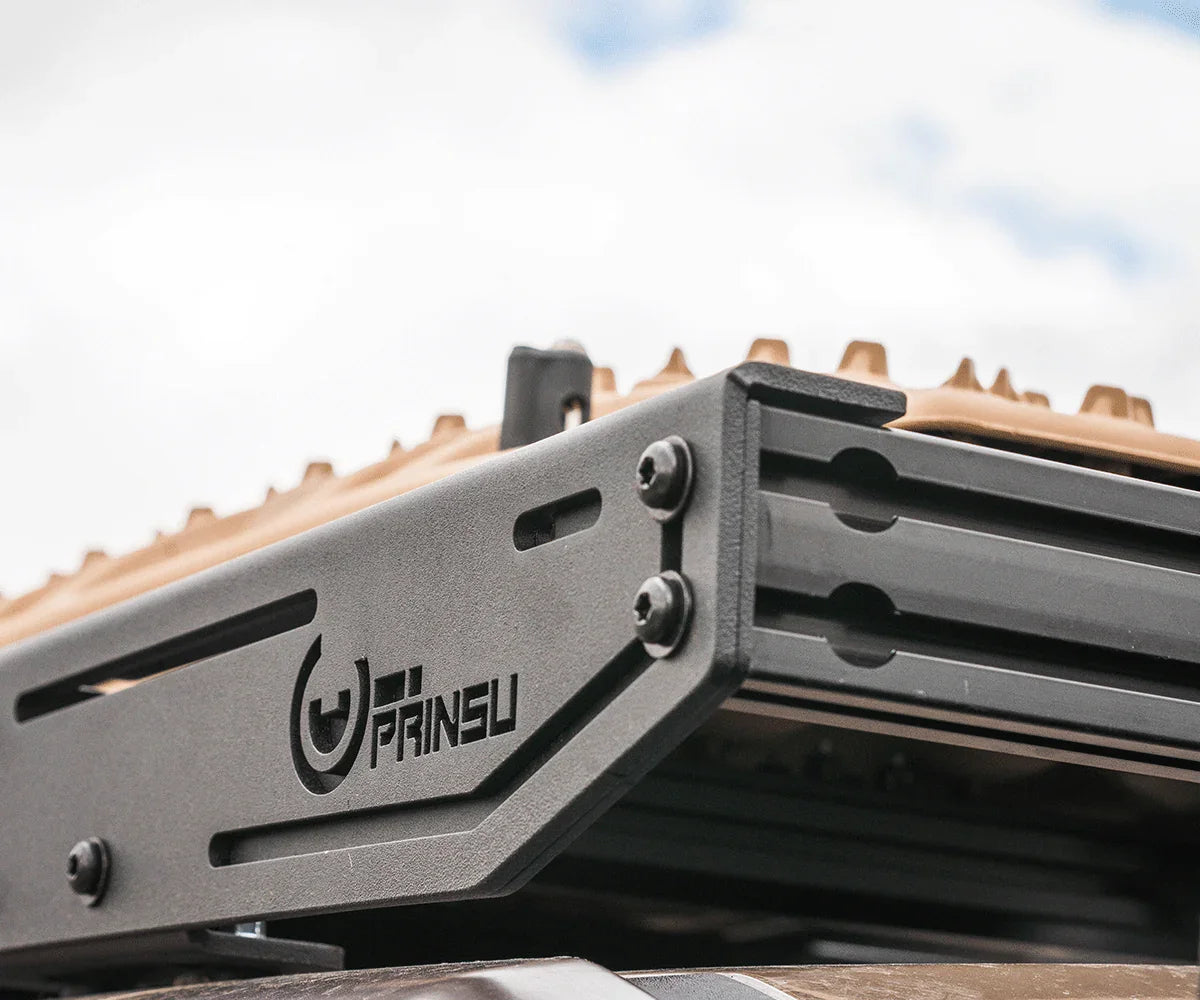 Close-up of Prinsu roof rack with tan recovery boards, mounted on a vehicle for overlanding.