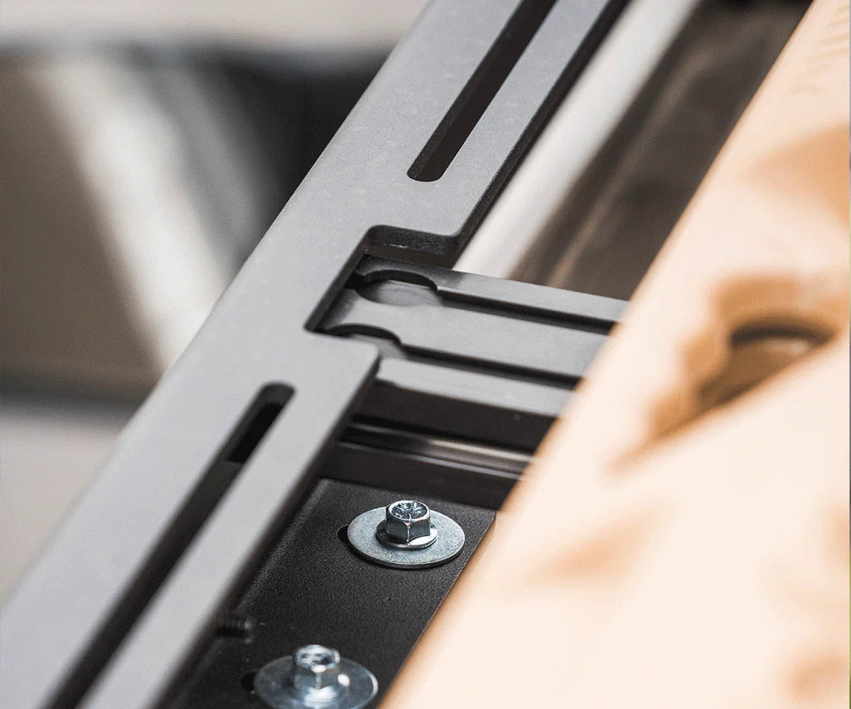 Close-up of heavy-duty roof rack mounting bracket with bolts for overlanding vehicle gear