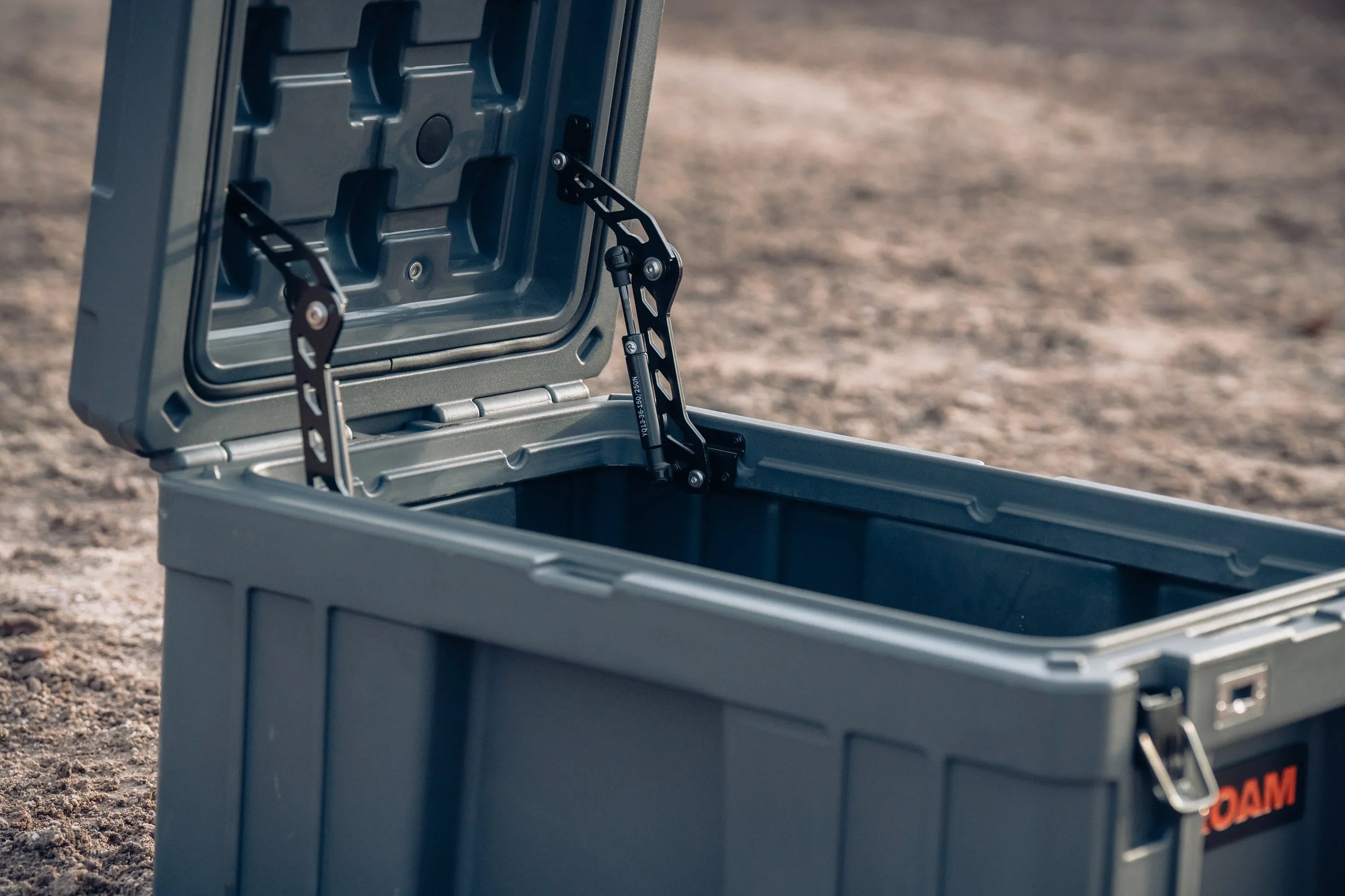 Heavy-duty overlanding storage box with reinforced lid and latches on outdoor ground