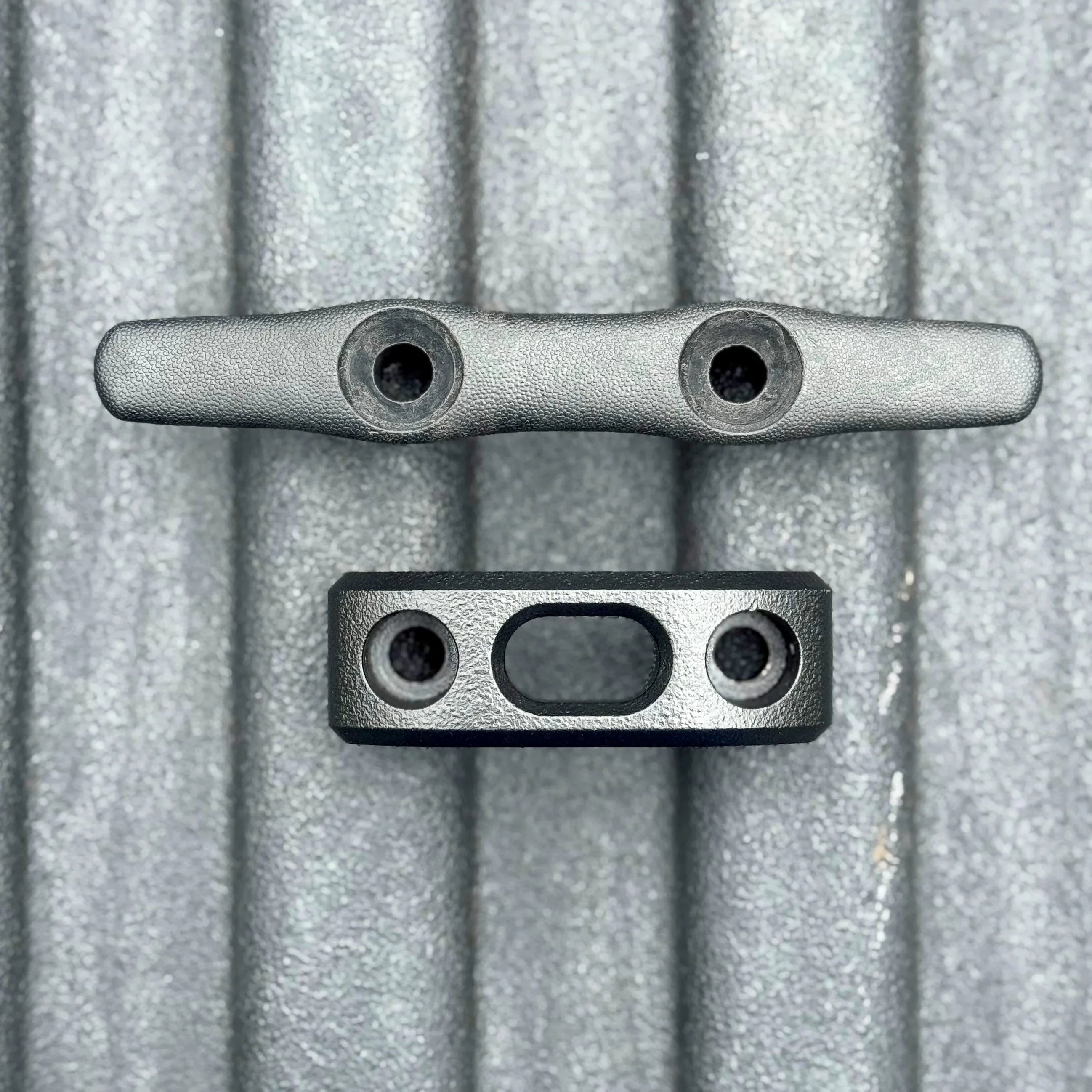 Truck bed tie down anchor cleat and mounting bracket on textured metal surface
