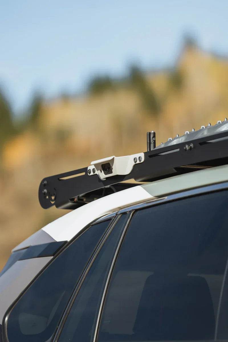 Close-up of a black metal roof rack handle mounted on a vehicle for overlanding gear