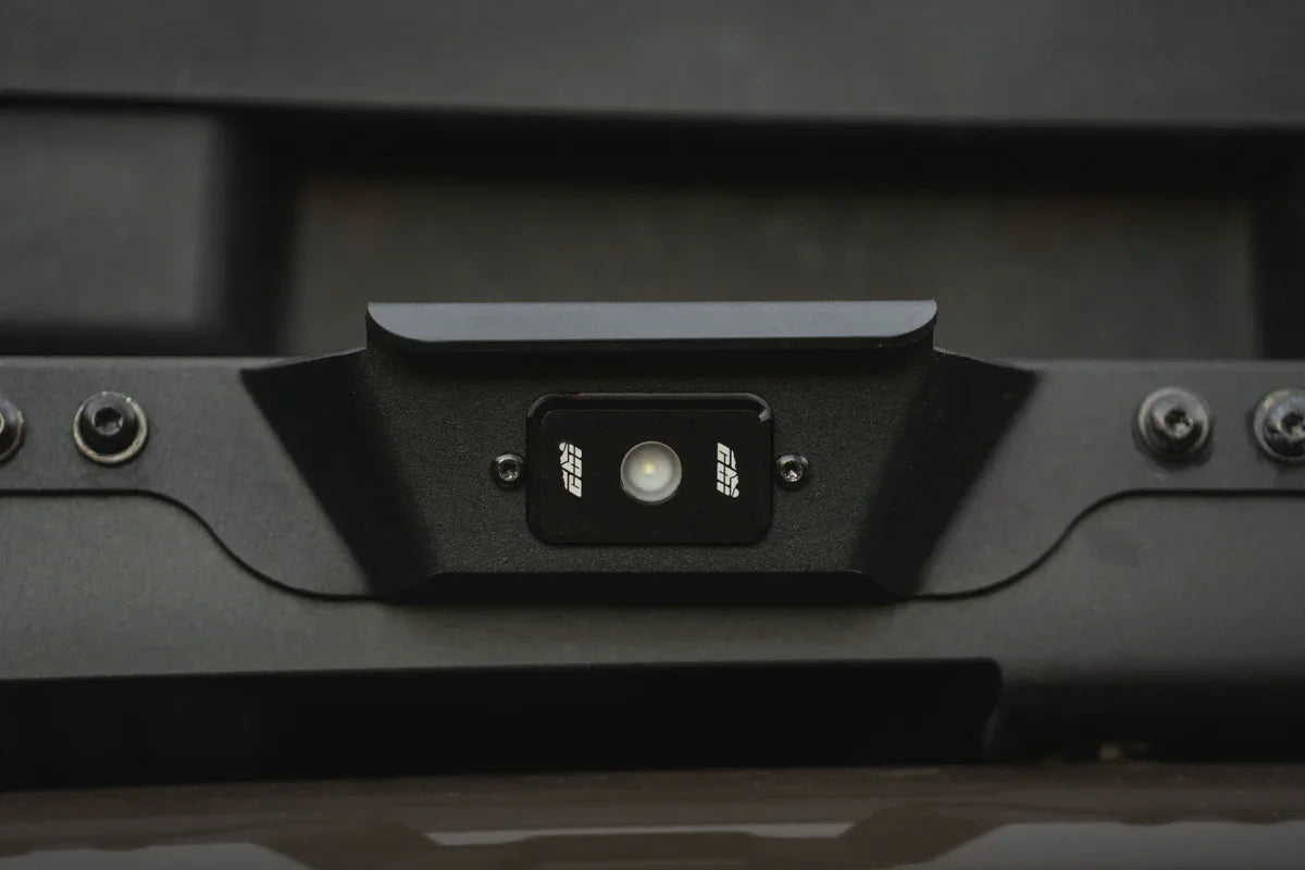 Close-up of a black overlanding vehicle handle with integrated LED light and bolts