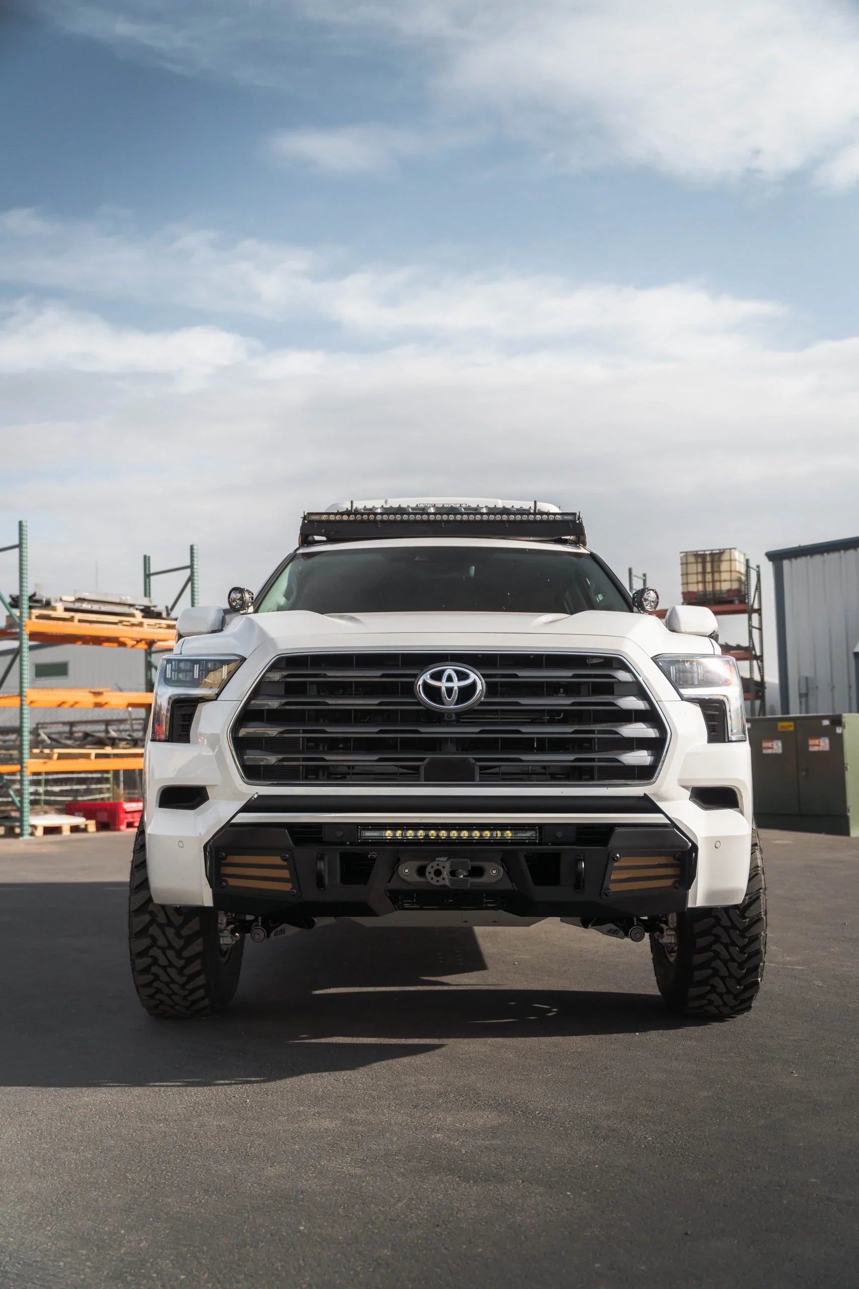 Front view of white Toyota Tundra with off-road accessories and LED light bar outdoors
