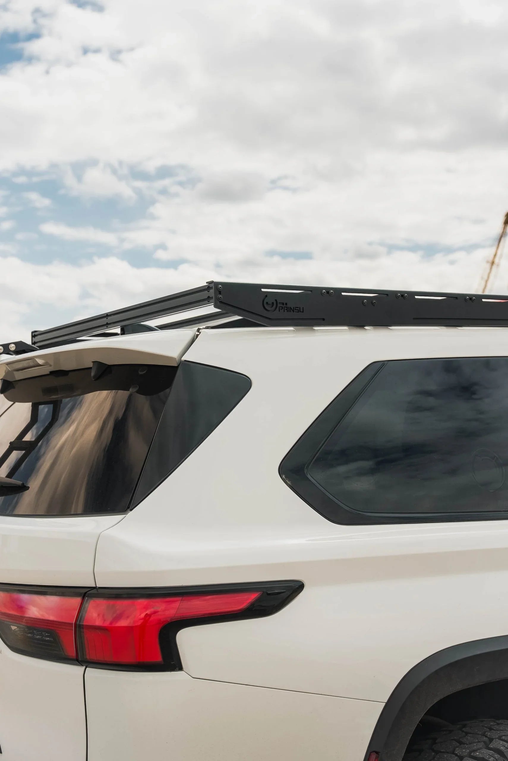 Black roof rack mounted on a white SUV, ideal for overlanding and expedition gear