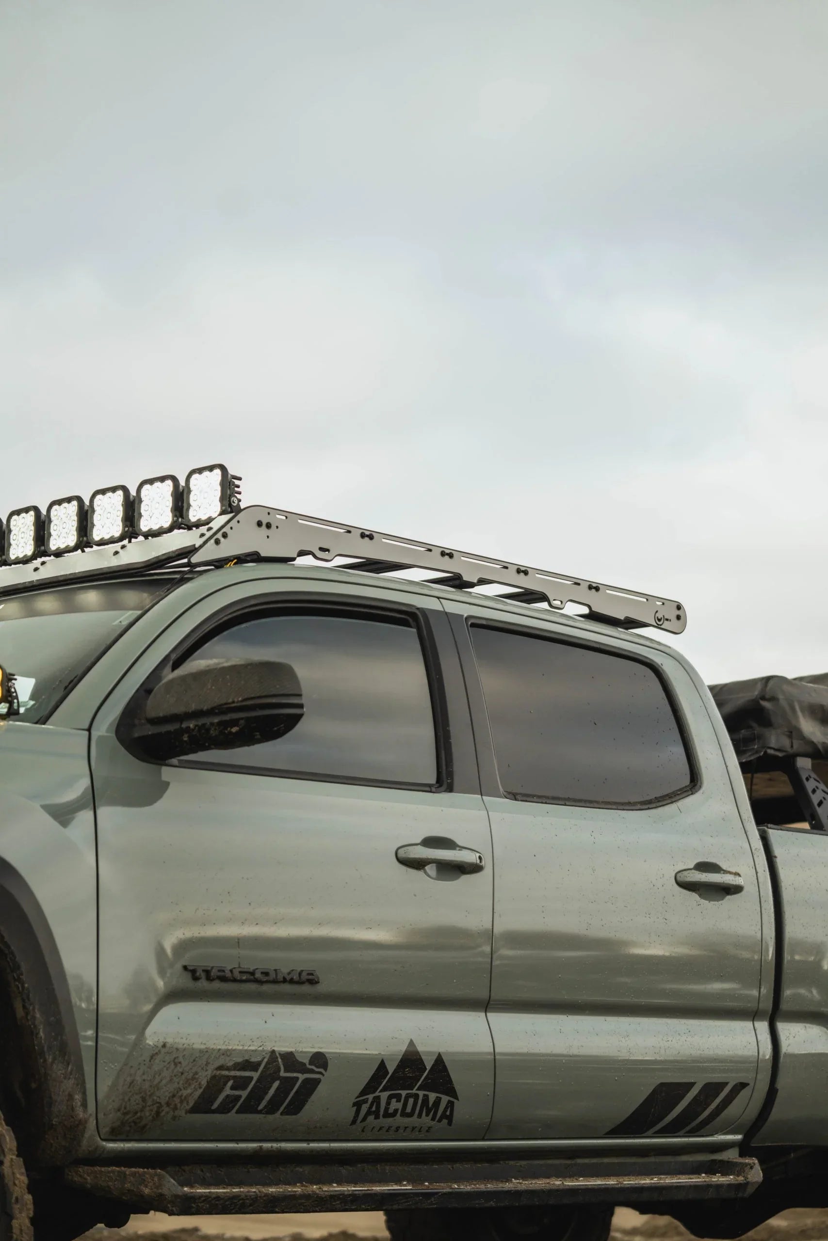 Toyota Tacoma side view with off-road roof rack and LED lights, overlanding accessories