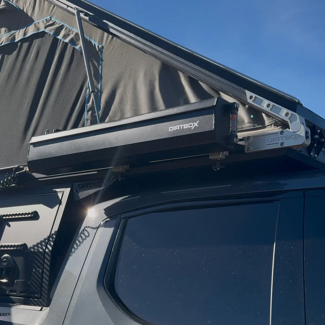 Side-mounted overland water tank on adventure vehicle with rooftop tent