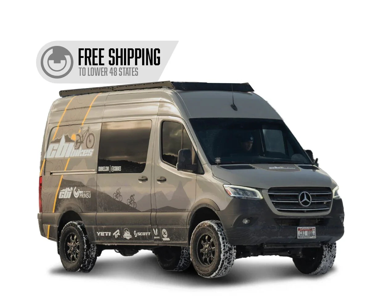 Mercedes Sprinter van with off-road tires, overlanding graphics, roof rack, and free shipping banner