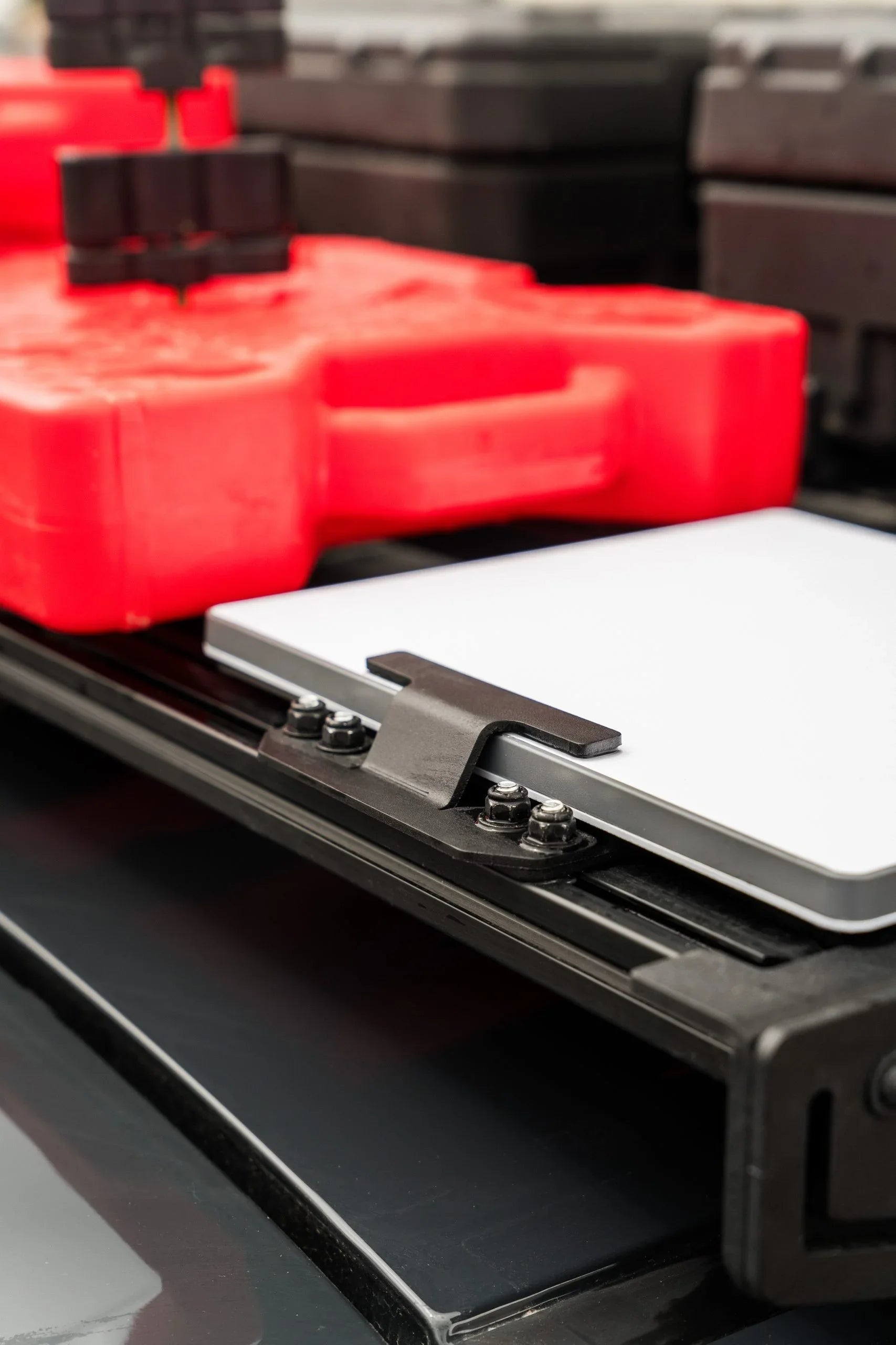 Starlink mount securely attached to vehicle roof rack with red recovery board nearby