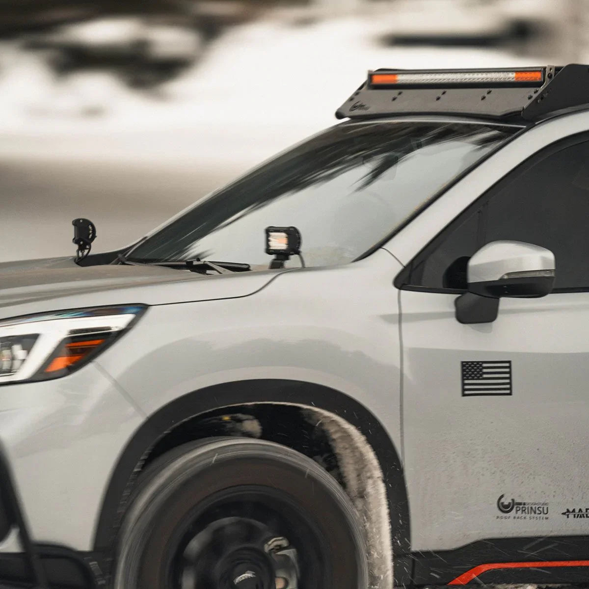 Subaru Forester with Prinsu roof rack and hood lights driving in snowy outdoor setting