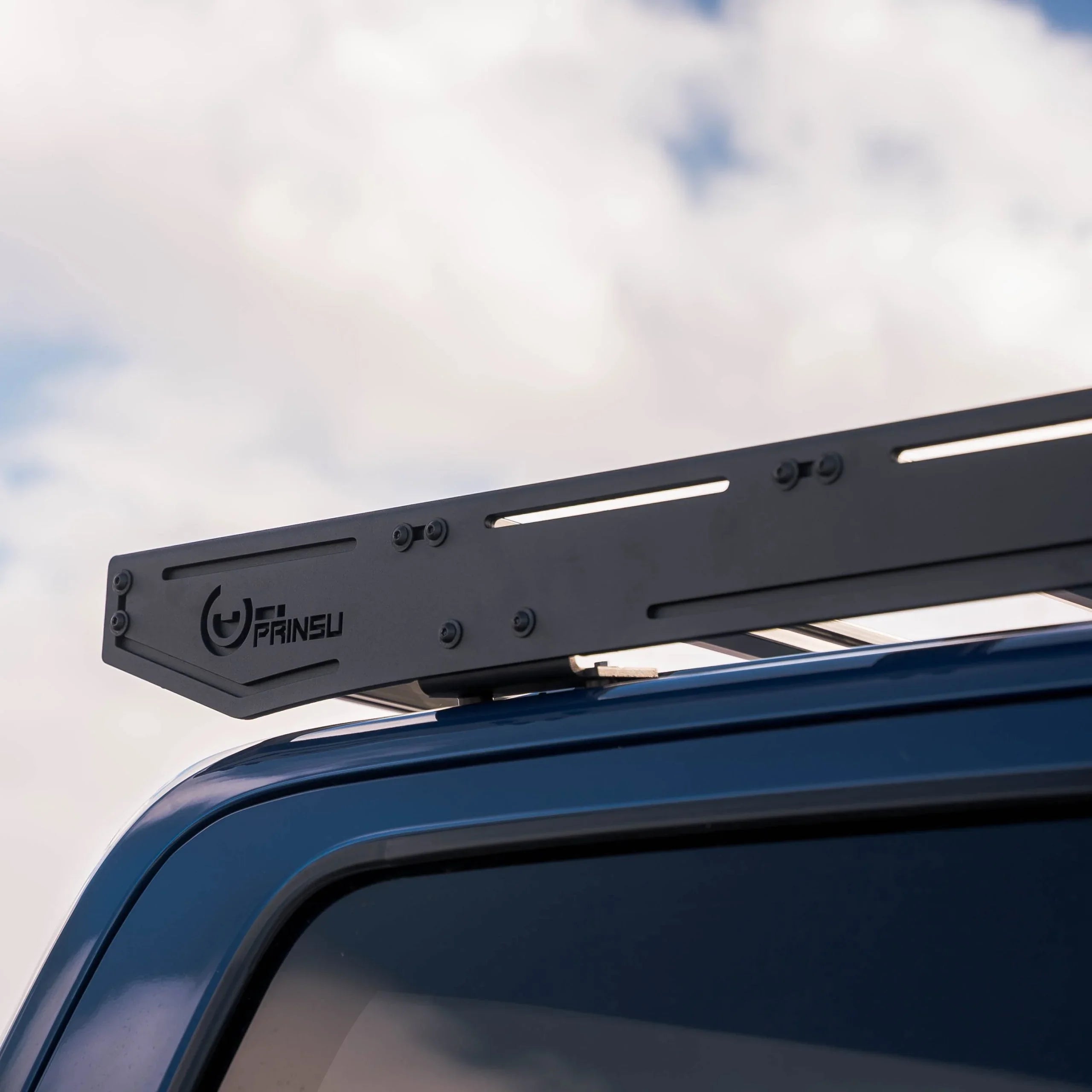 Closeup of metal roof rack mounted on blue vehicle for overlanding or camping