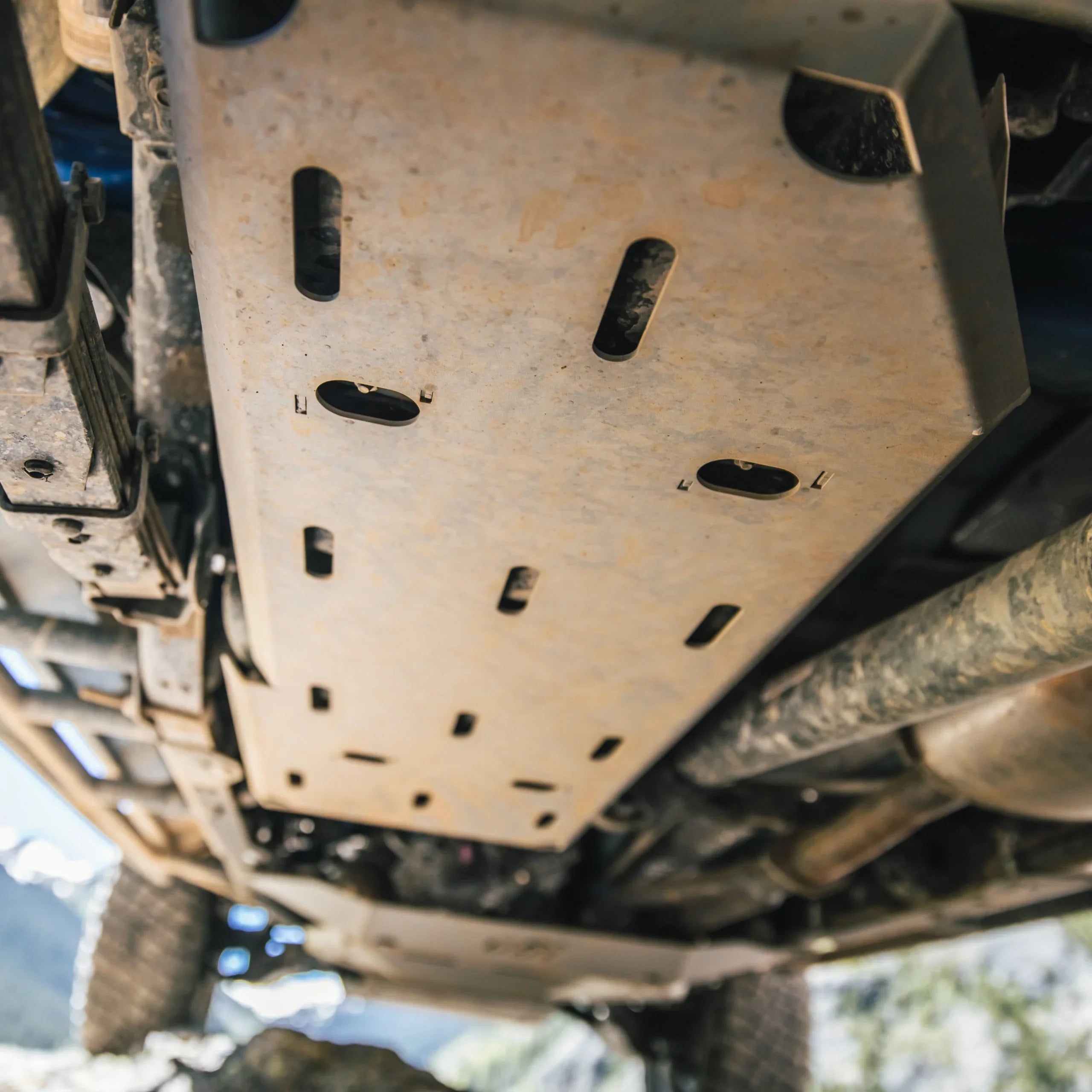 Heavy-duty off-road vehicle skid plate protecting undercarriage in rugged terrain