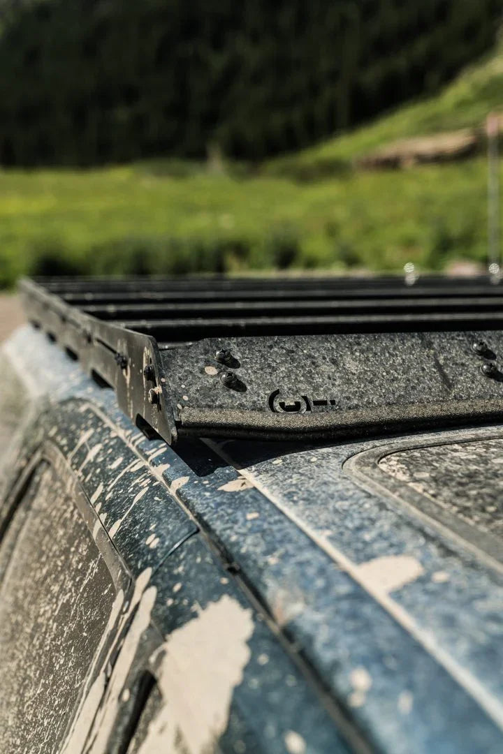 Close-up of Prinsu roof rack on a mud-splattered Toyota 4Runner, outdoor adventure setting