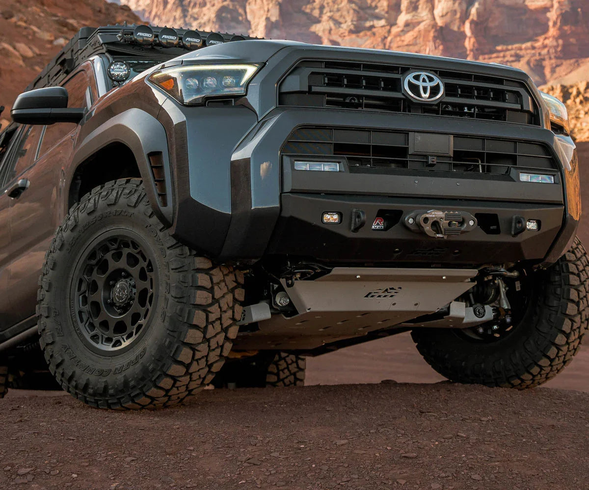 Toyota 4Runner with off-road tires, front bumper, and skid plate on a desert trail