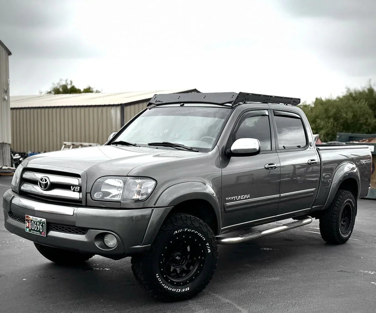 Toyota Tundra truck with overlanding roof rack and off-road tires in parking lot