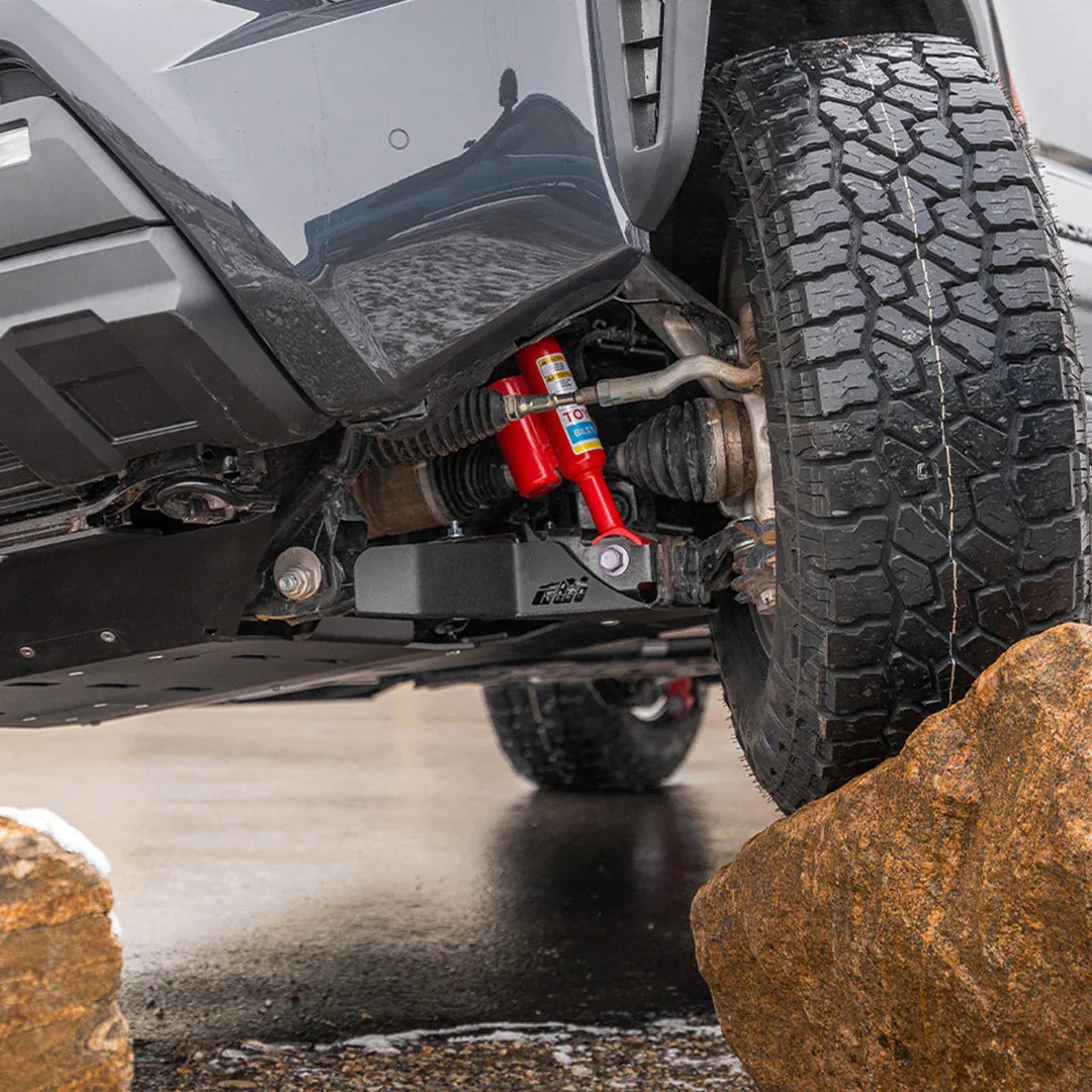 Toyota Tacoma front skid plate and suspension off-road on a rock