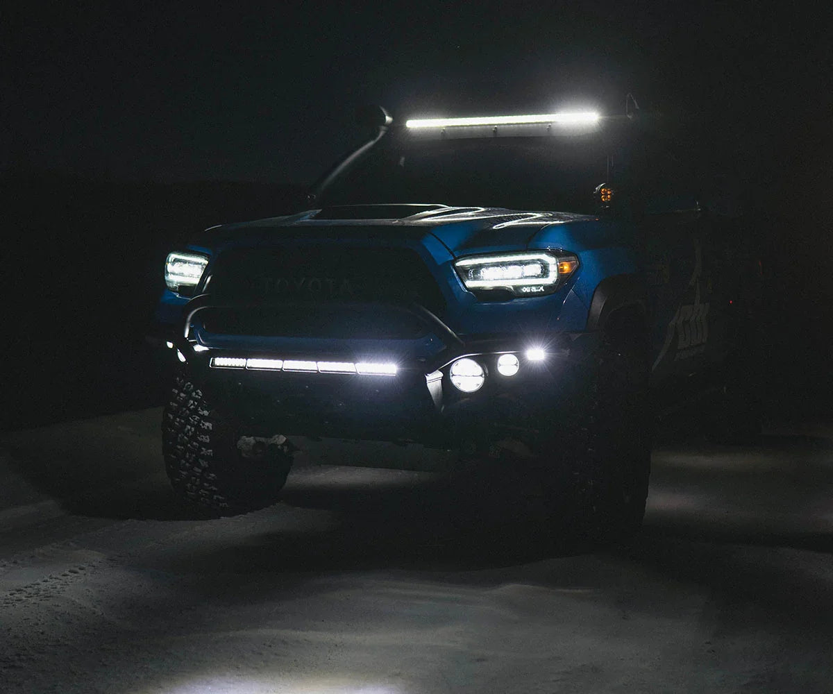 Toyota Tacoma with hybrid front bumper and LED light setup for overlanding at night