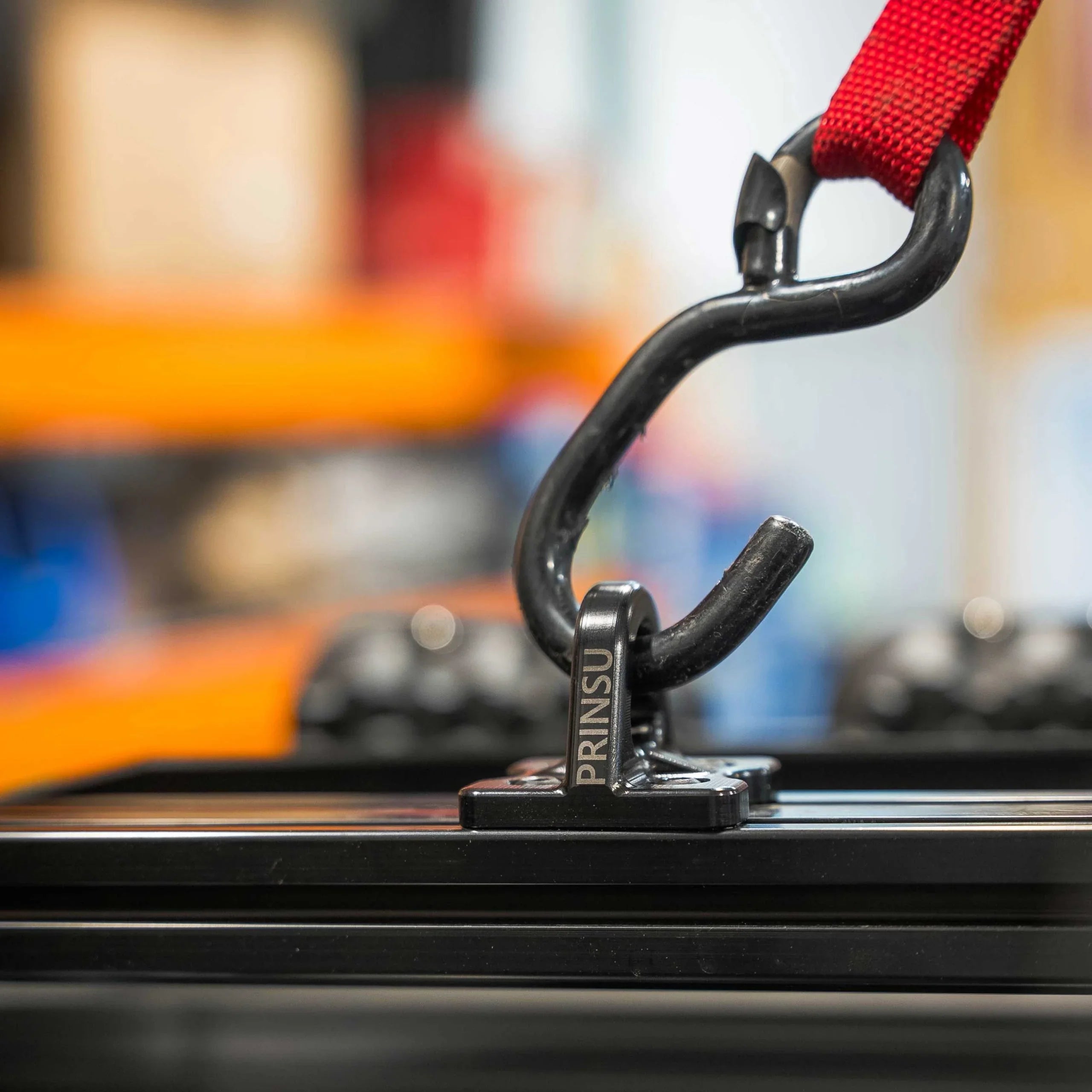 Close-up of a roof rack tie-down point with red strap and hook for off-road vehicles