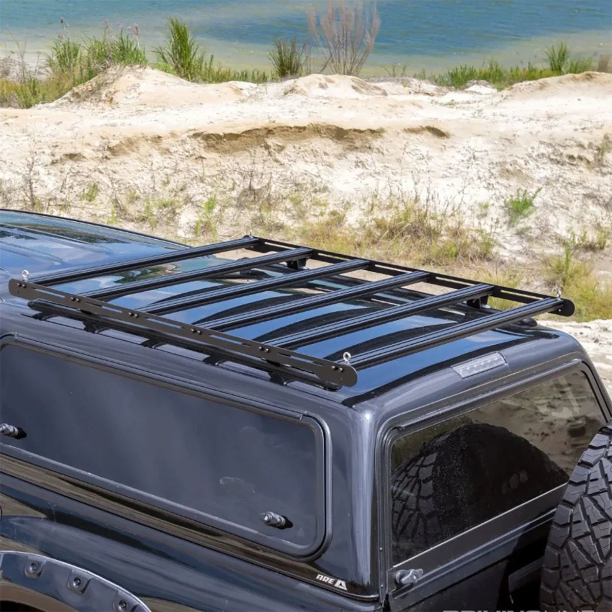 Overland vehicle roof rack on SUV for camping and adventure gear by a lake