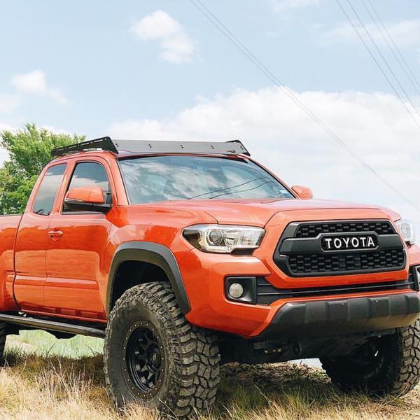 Toyota Tacoma with Prinsu roof rack and off-road tires parked outdoors
