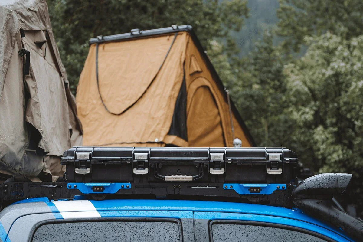 Toyota Tacoma with Prinsu roof rack, storage case, and mounted rooftop tent in forest setting