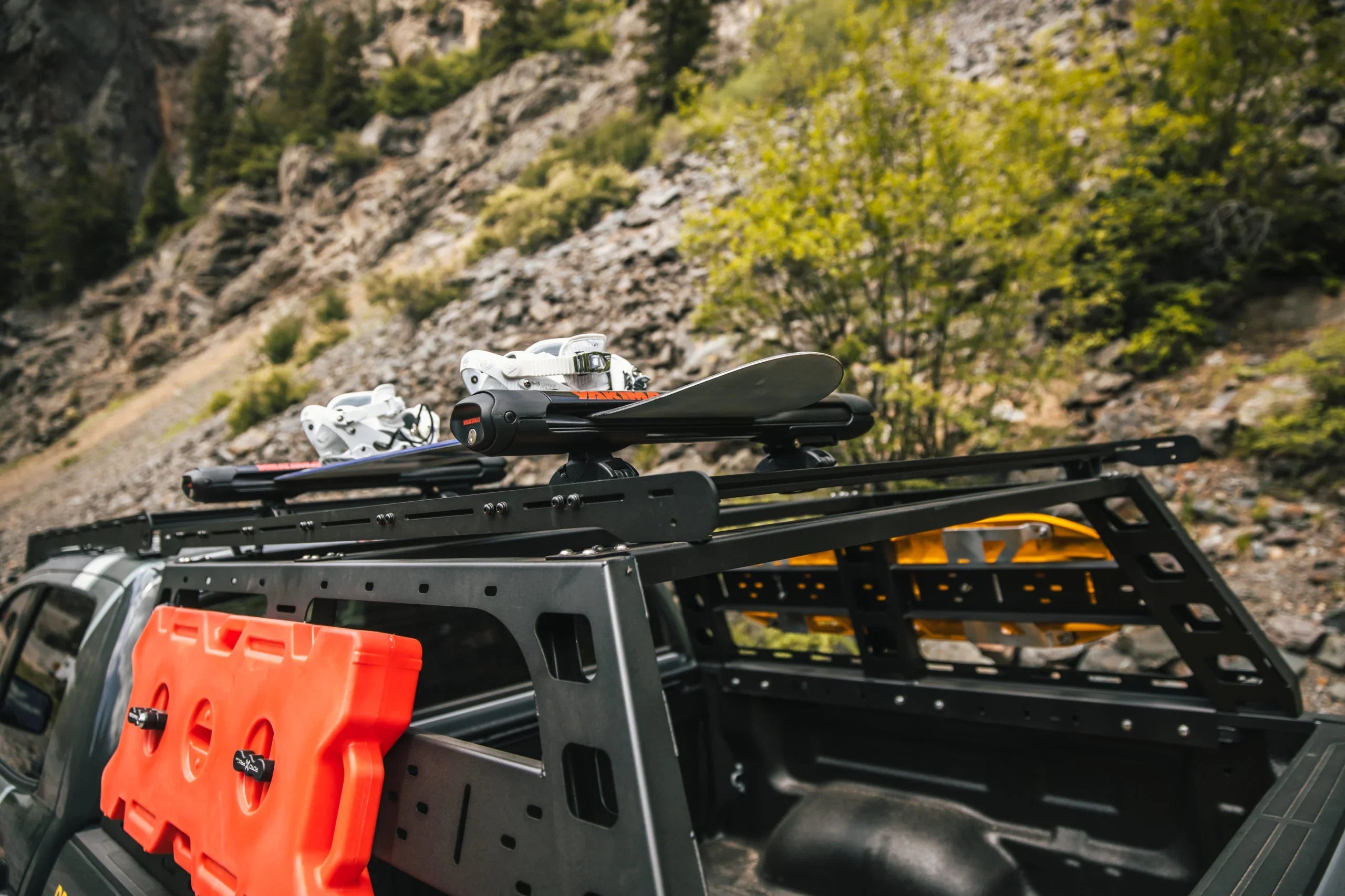 Toyota Tundra bed rack with snowboard carrier and gear, outdoor adventure setting