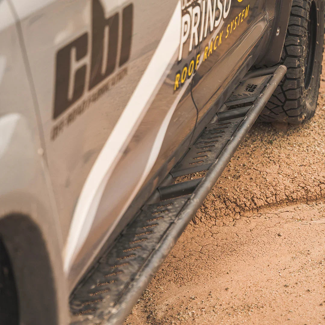 Toyota Tundra overland rock sliders mounted on truck side, off-road setting