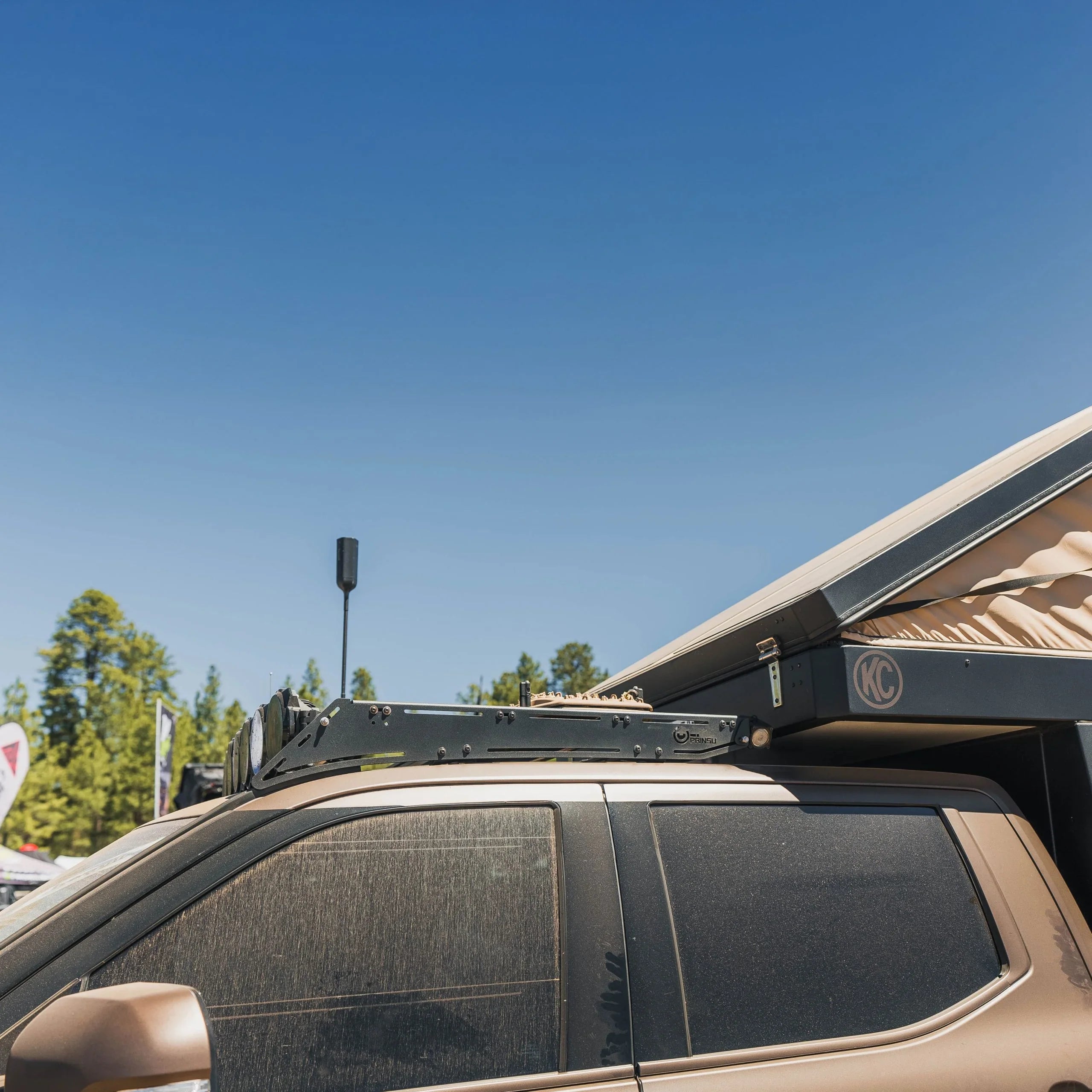 Toyota Tundra with camper rack and rooftop tent for overlanding, outdoors background