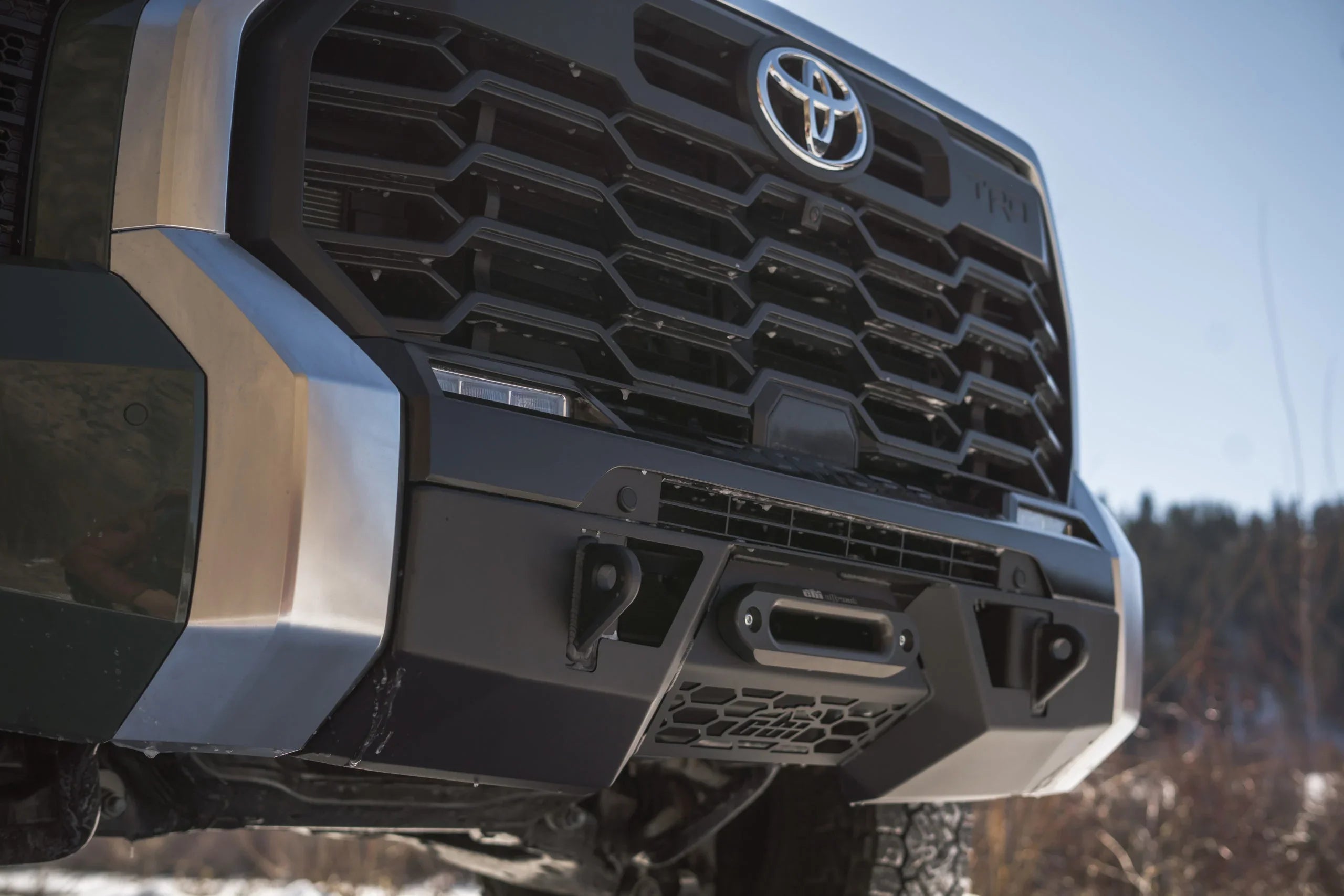 Close-up of Toyota Tundra TRD front grille with off-road bumper and winch mount